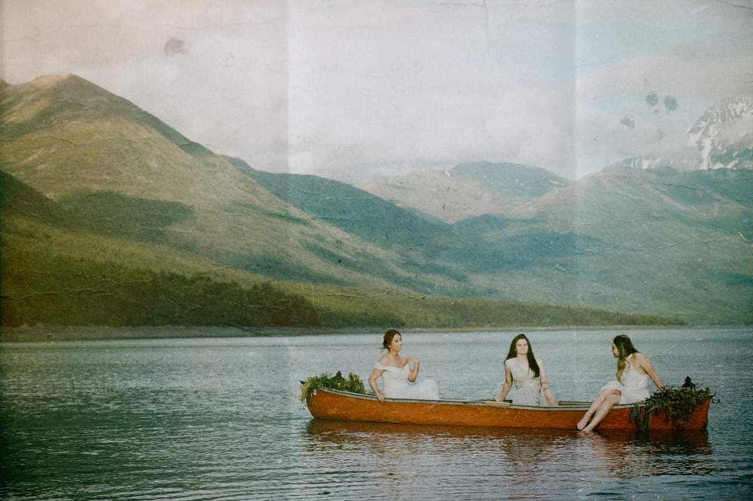 People enjoying a canoe ride on a serene mountain lake surrounded by peaks.