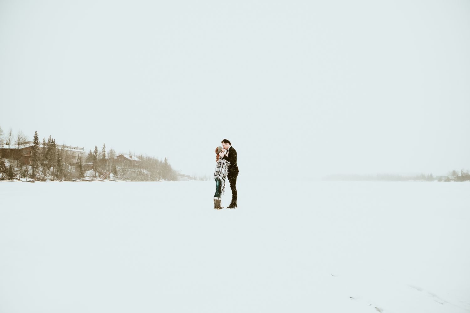 Minimalist winter landscape with distant figures in snow.
