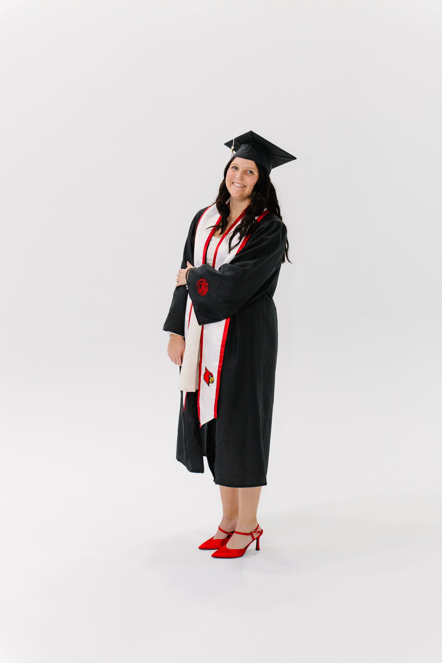 Graduate in black cap and gown with red heels poses in multiple positions against white background.