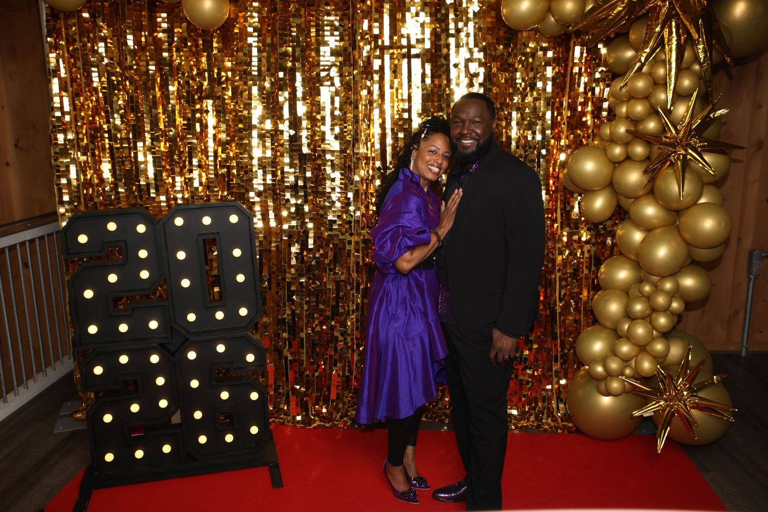 A romantic photo series with a couple posing against a sparkly gold backdrop with twinkling lights.