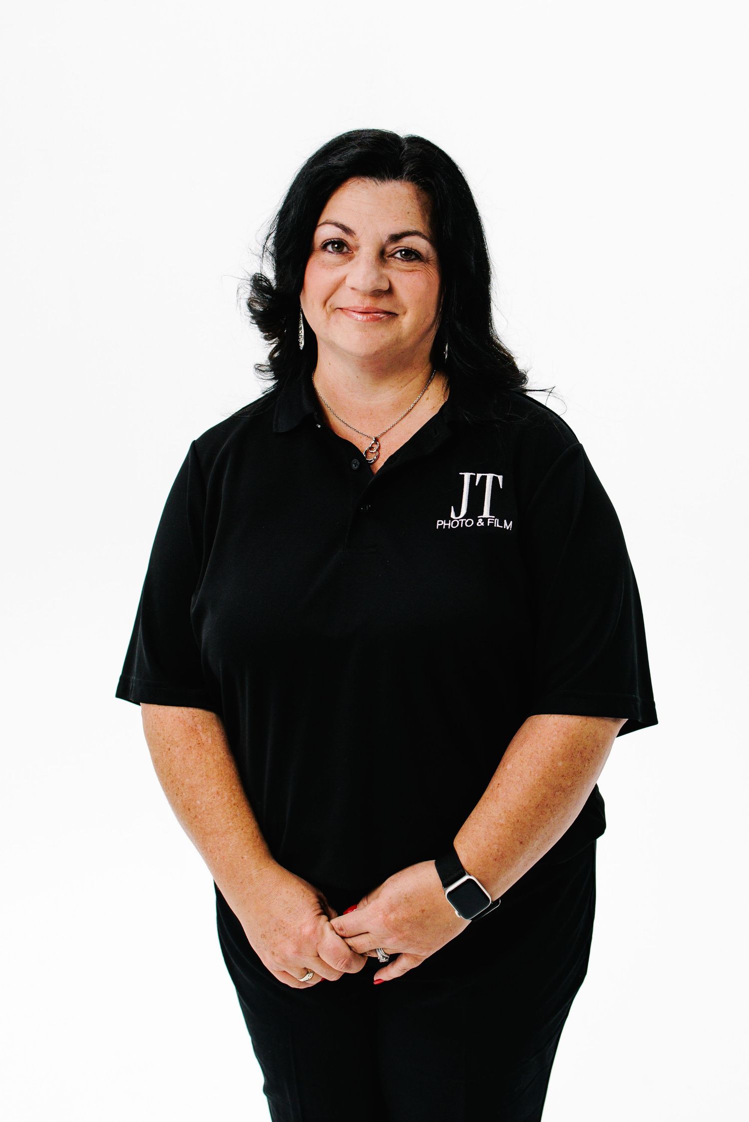Professional wearing black polo shirt and dark pants poses in multiple casual standing positions against white background.