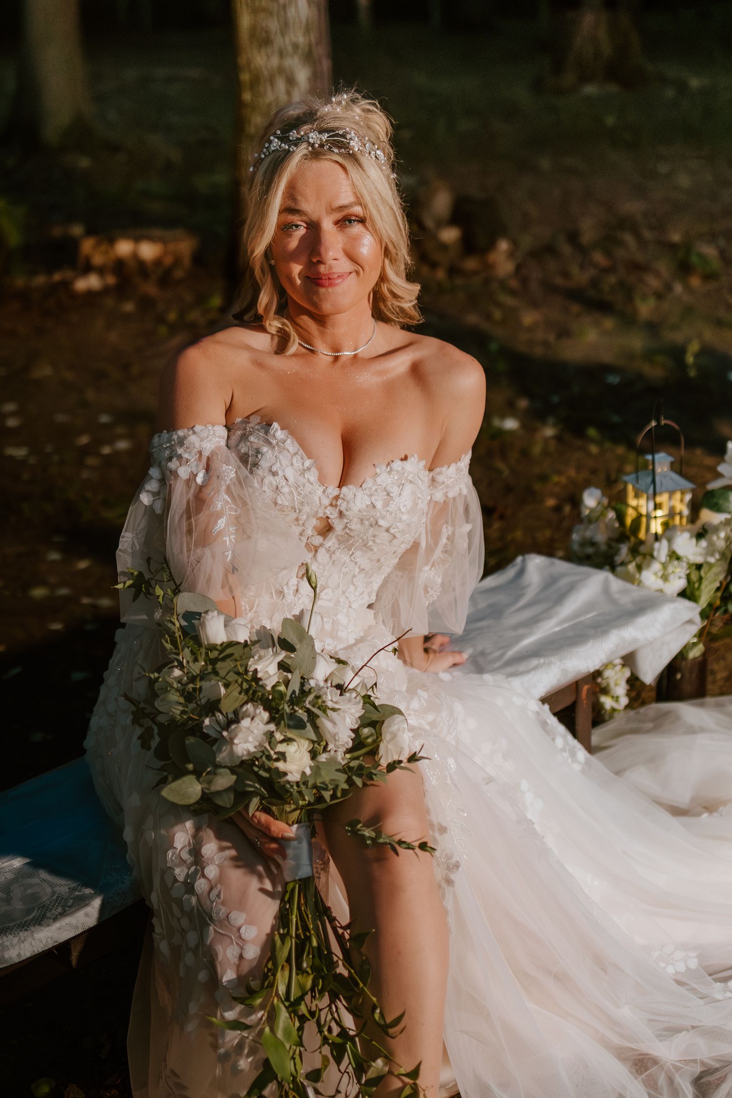A wedding dress with delicate lace details and floral embellishments is displayed in a series of romantic forest photos.