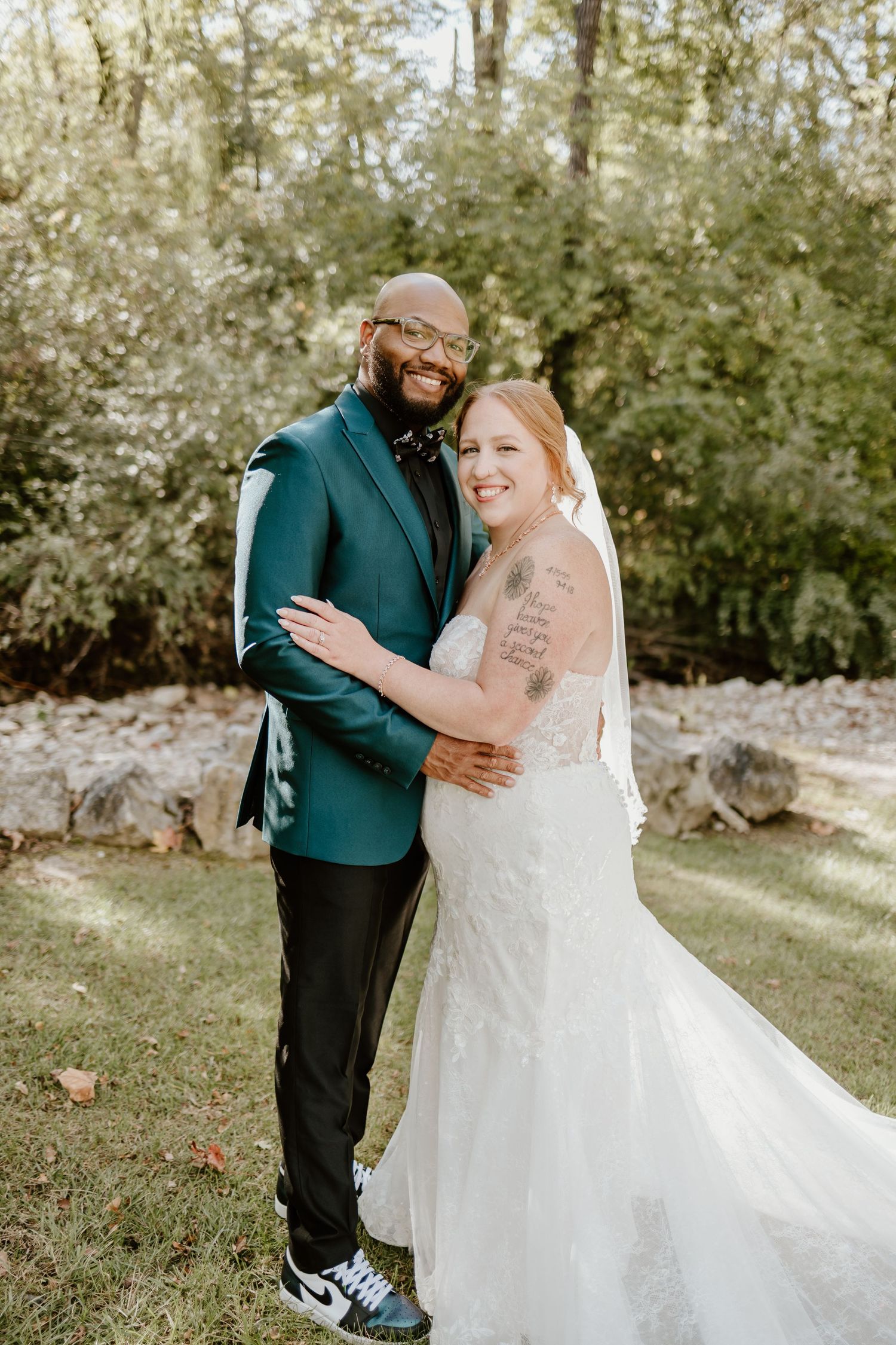 A couple shares a tender moment during their outdoor wedding photoshoot, with the bride wearing a beautiful white gown.