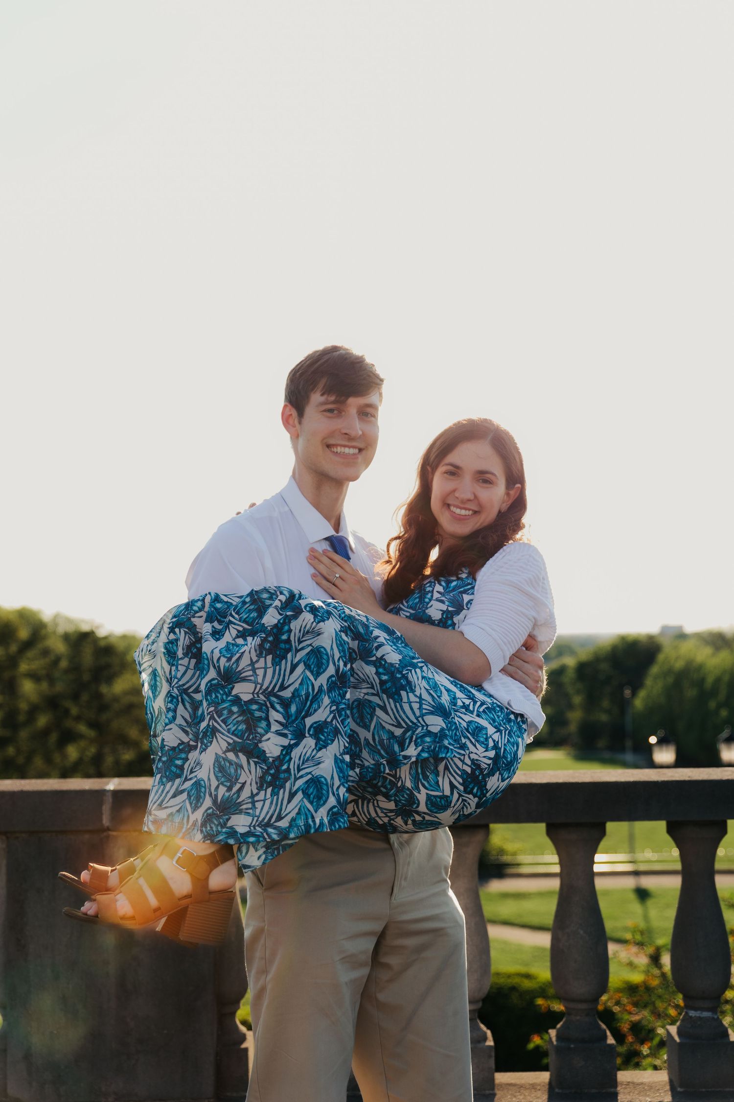 A joyful couple sharing a romantic moment against a sunset backdrop.