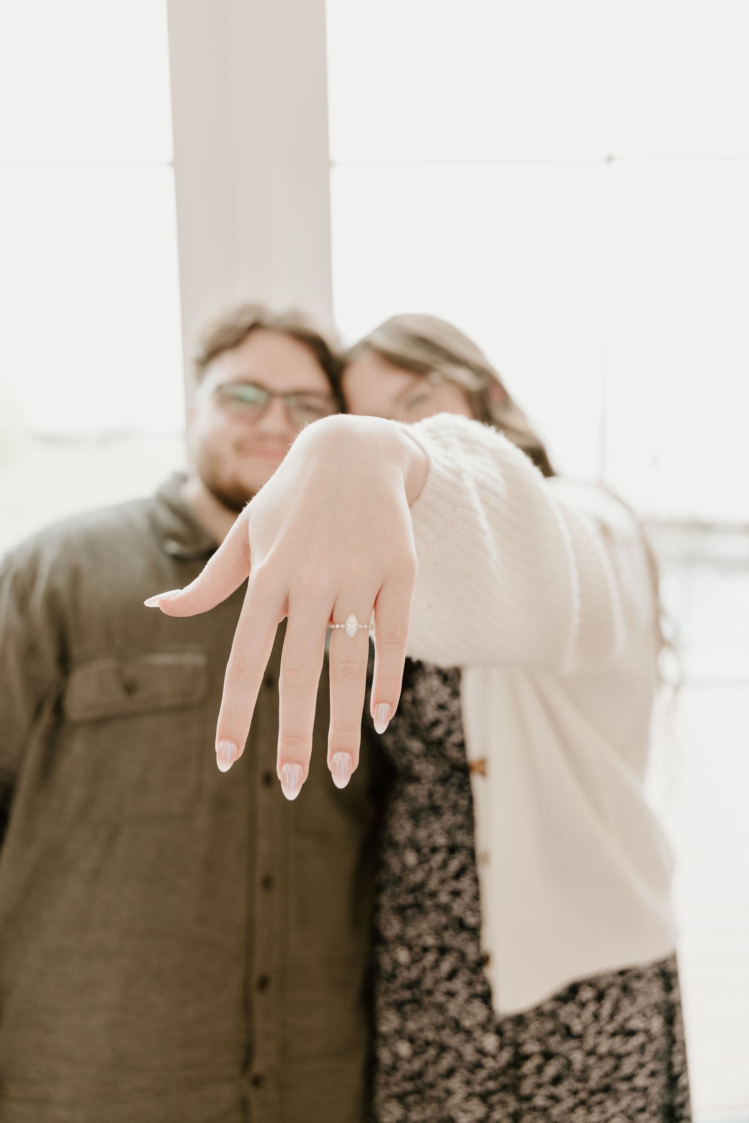An artistic engagement photo showing a ring with soft white interior lighting.