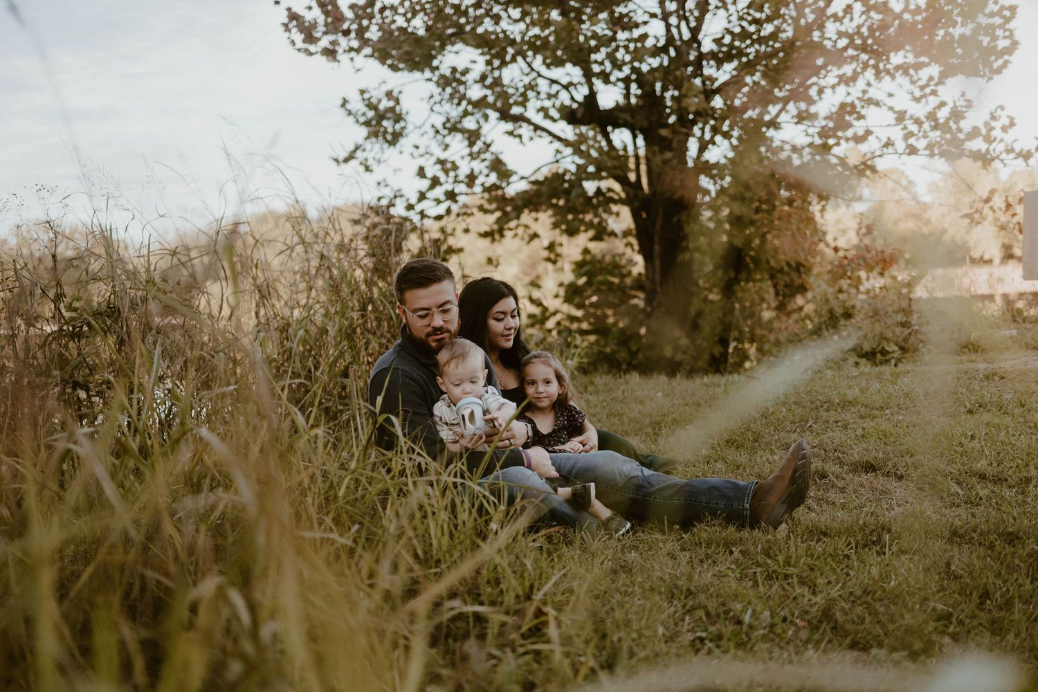 Candid family moments captured in natural outdoor setting during golden hour.