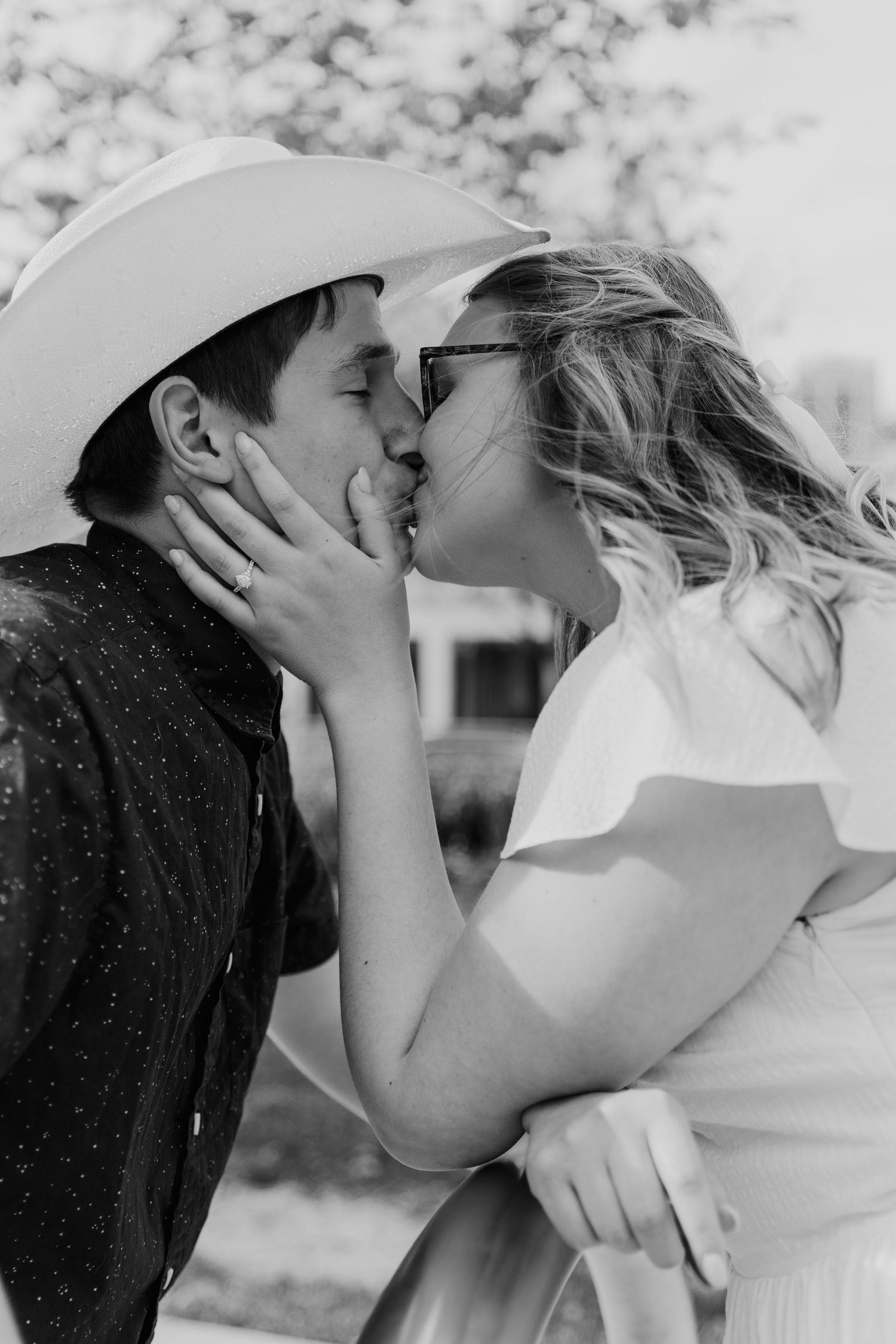 Intimate black and white portrait of couple sharing romantic moment outdoors.