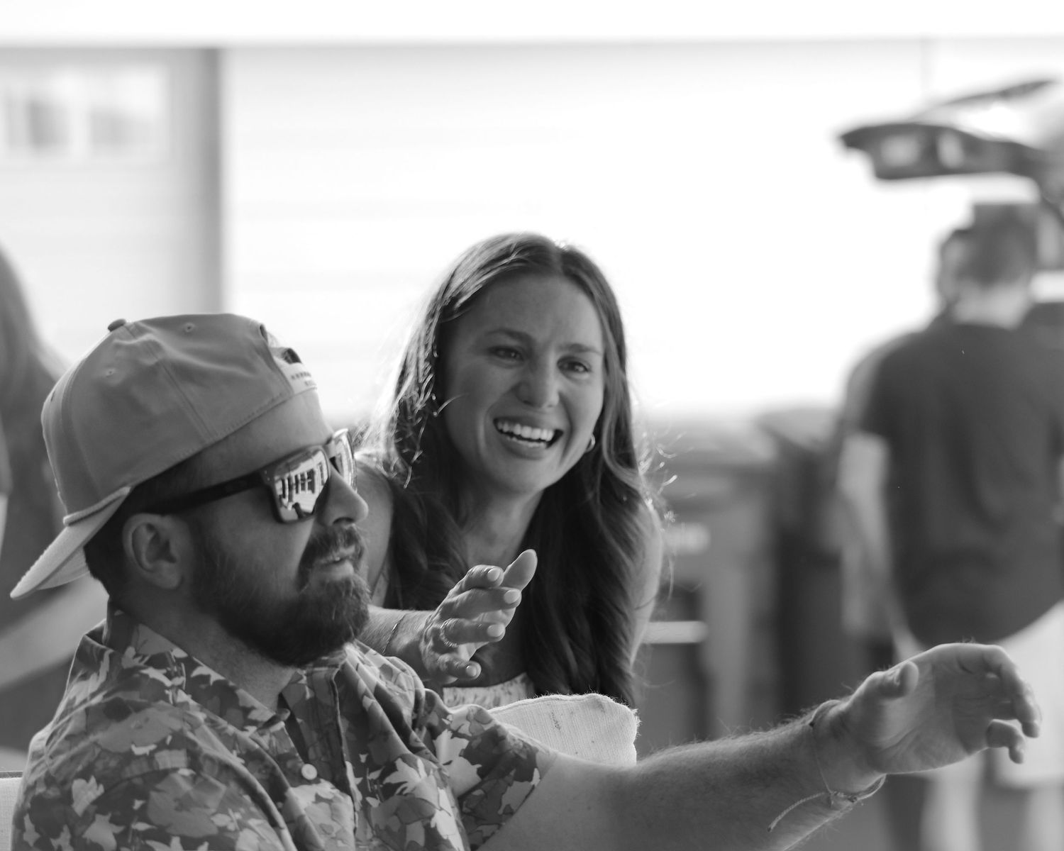 A black and white photo montage shows romantic candid moments between a couple at an outdoor event.