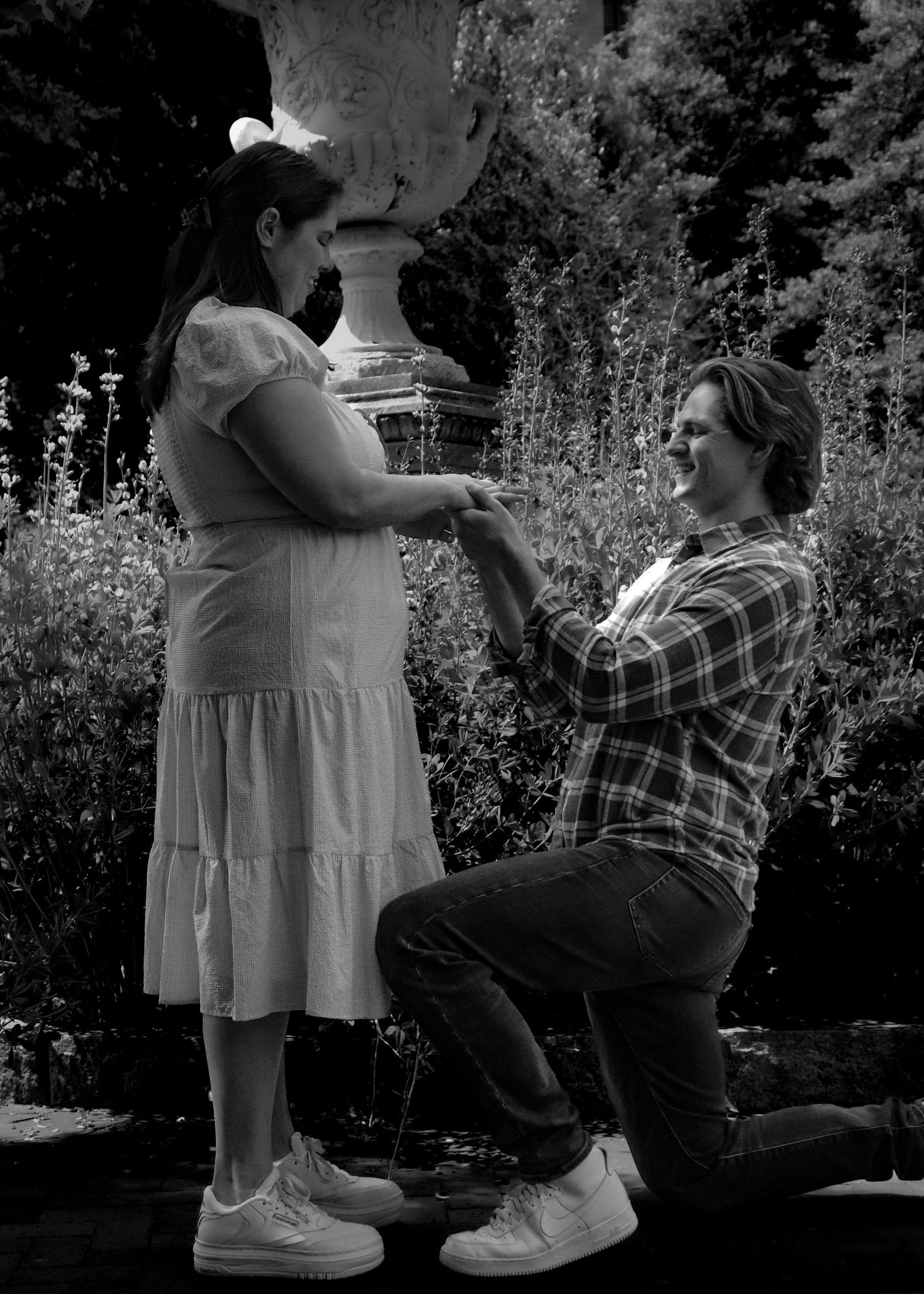 Black and white photo of romantic proposal in Washington DC garden, engagement photography.