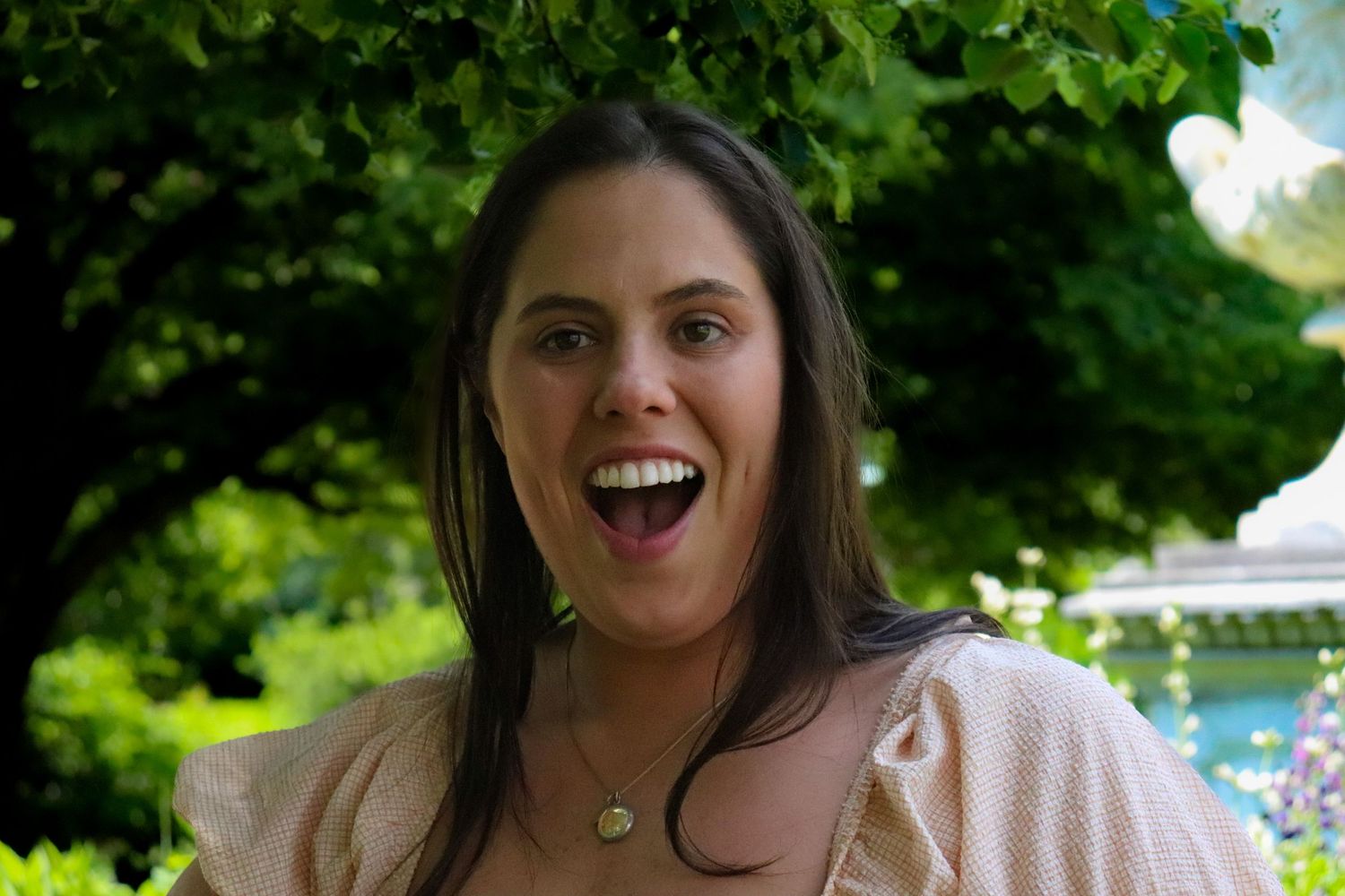 Bride-to-be laughing during Smithsonian Castle engagement session in DC garden, candid portrait.