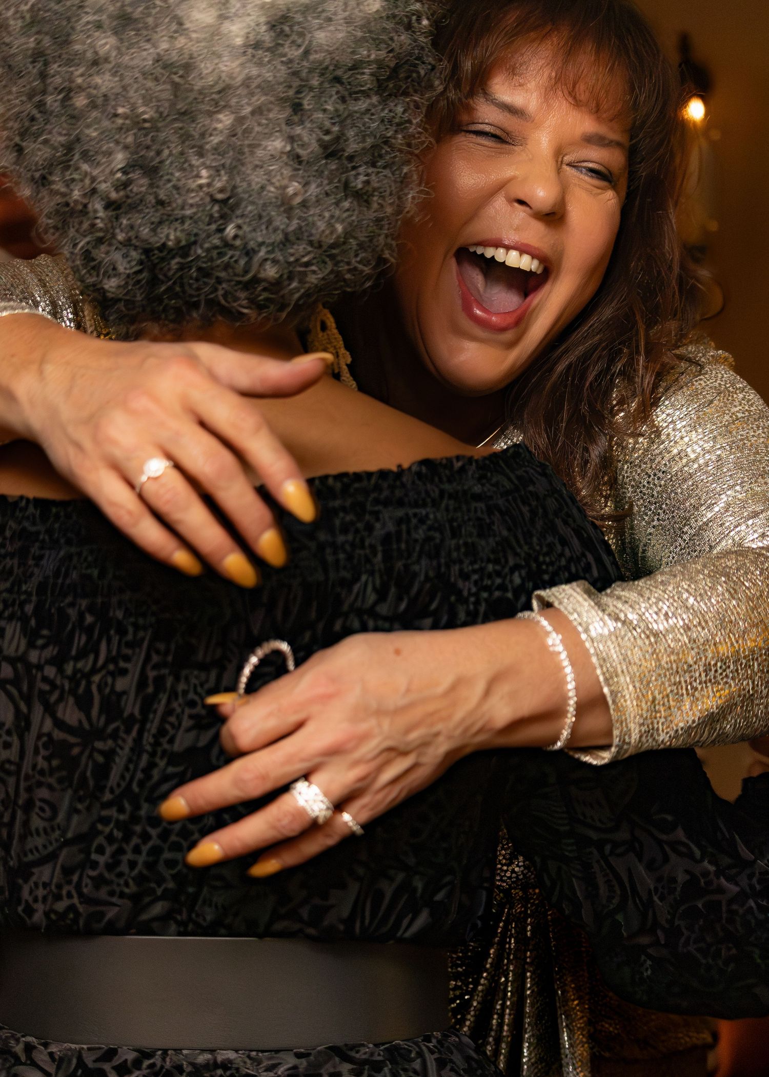 Close-up shots of hands with yellow nail polish and sparkling jewelry against a black textured background.