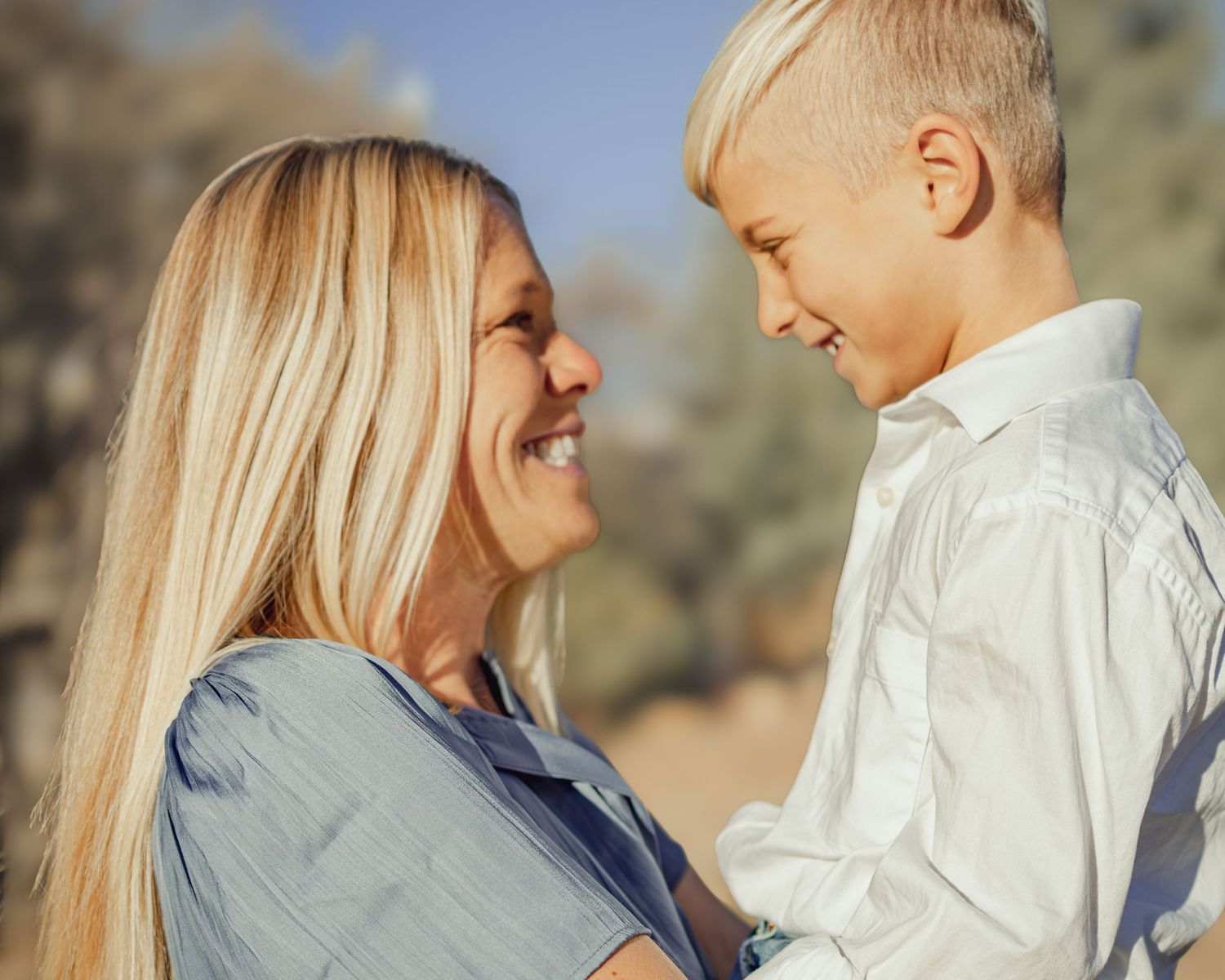A mother and young son share tender moments in a series of outdoor photos with warm natural lighting.