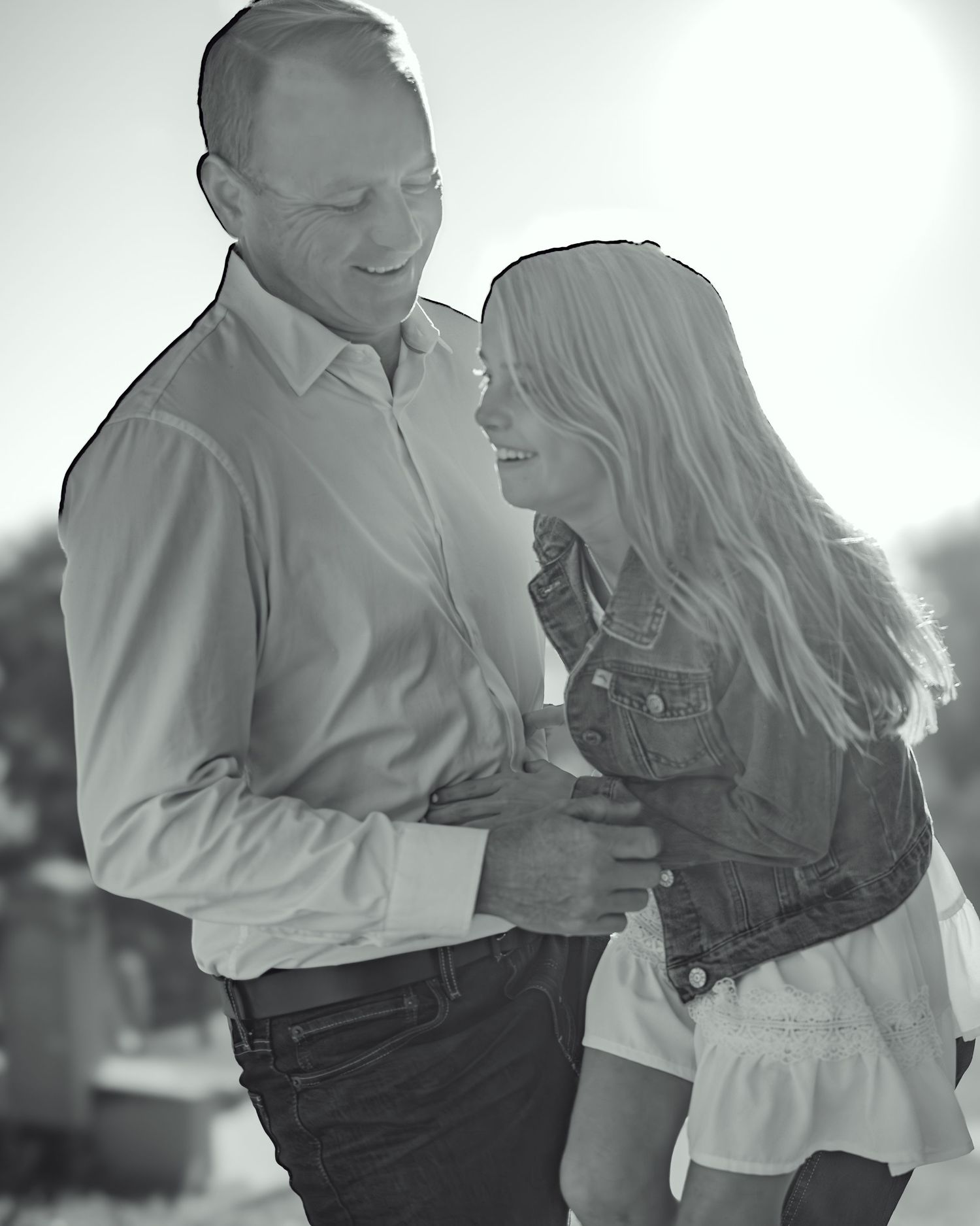 A couple shares an intimate black and white moment together while embracing and smiling.