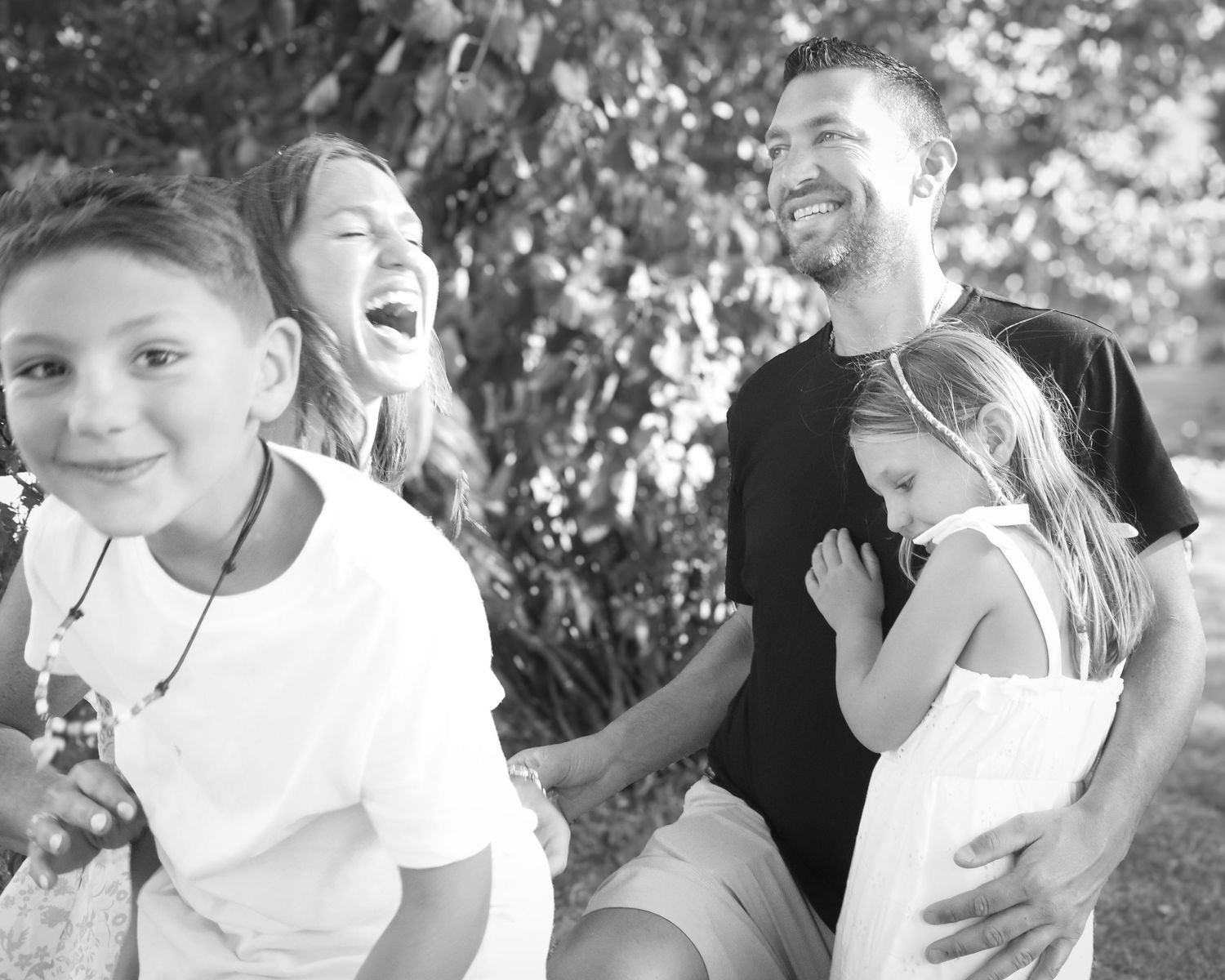 A black and white compilation of candid photos showing children making silly faces and laughing together.