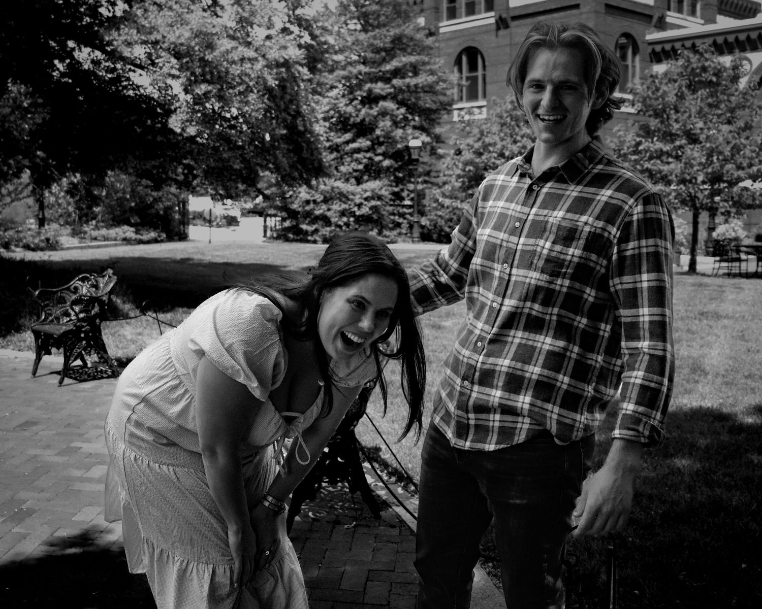 Black and white candid of engaged couple walking on garden pathway, Washington DC engagement session.