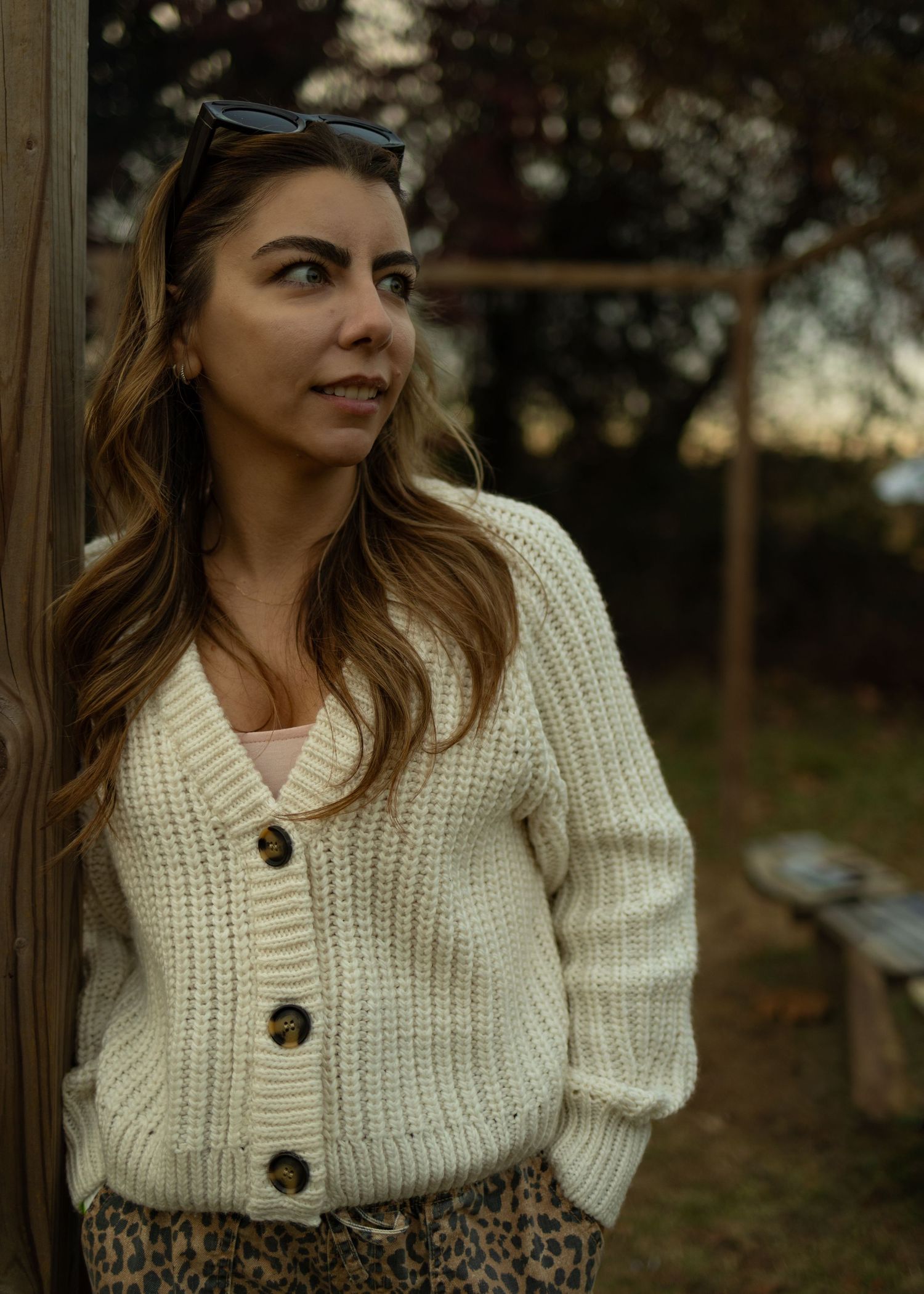 A collage of fashion photos showing a cream knit cardigan with large buttons paired with a leopard print skirt.