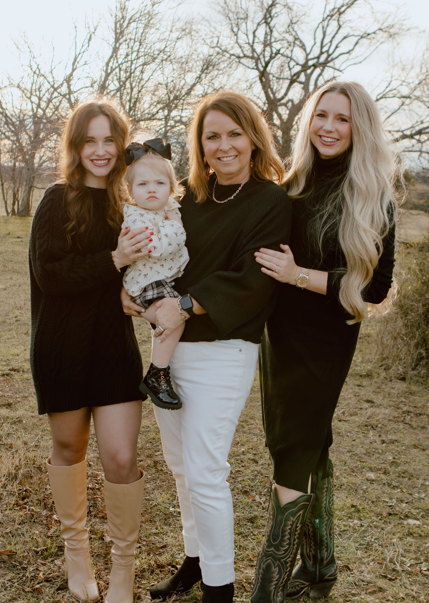 Group of women in black and white outfits pose together outdoors.