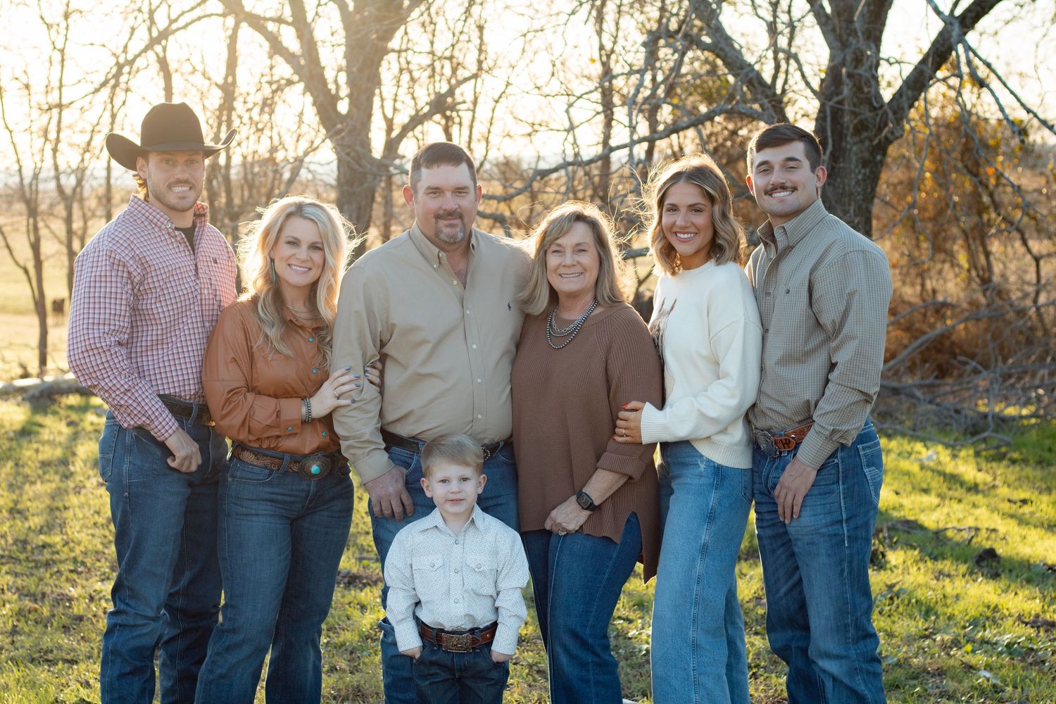 Family portrait session at sunset in a natural outdoor setting.