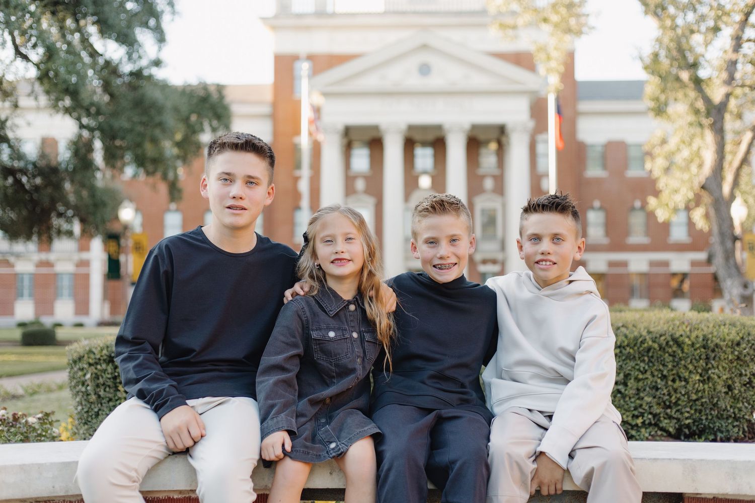 Family members posed casually against architectural backdrop with white columns.