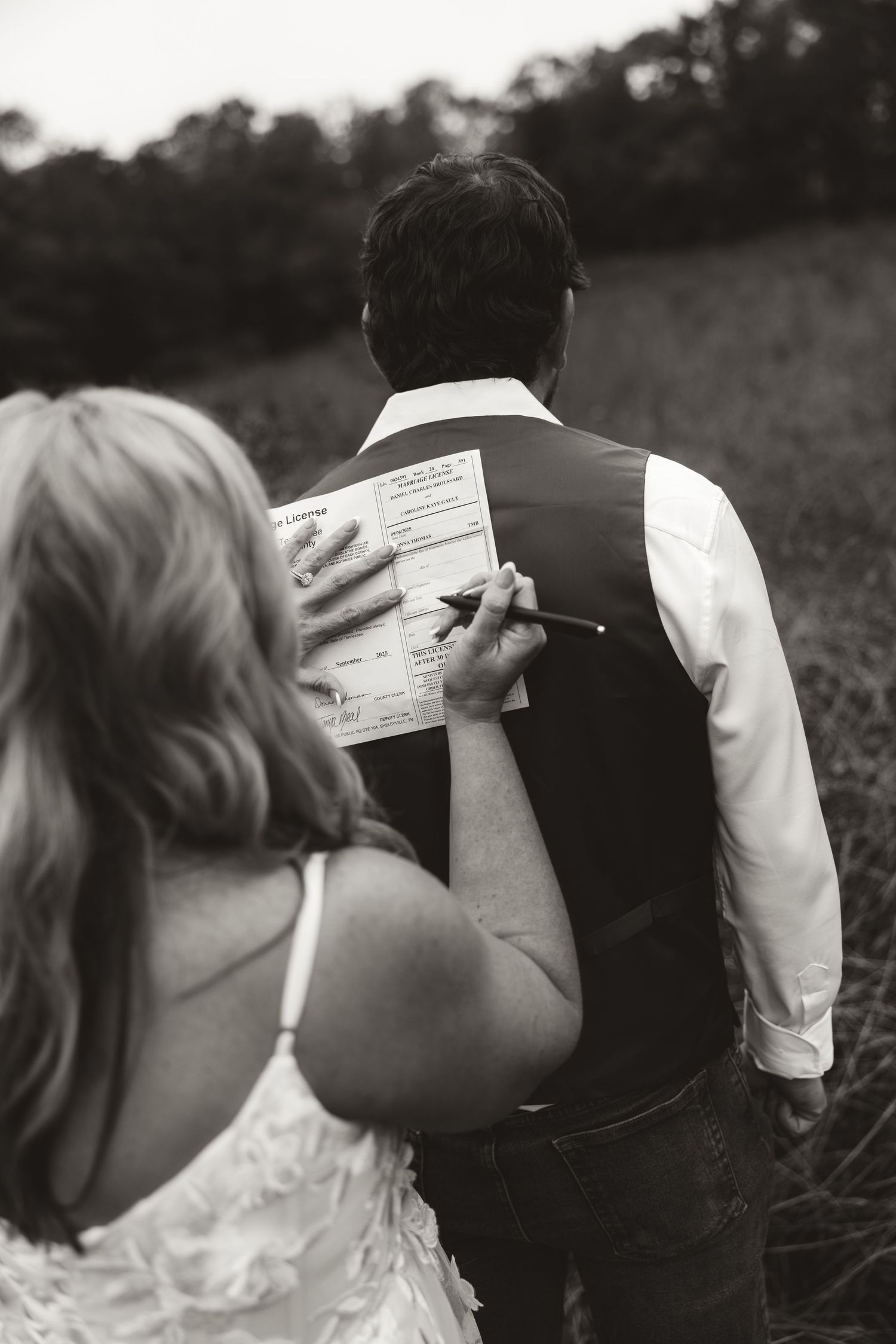 A progression of black and white photos showing a couple embracing and sharing a kiss in an outdoor setting.