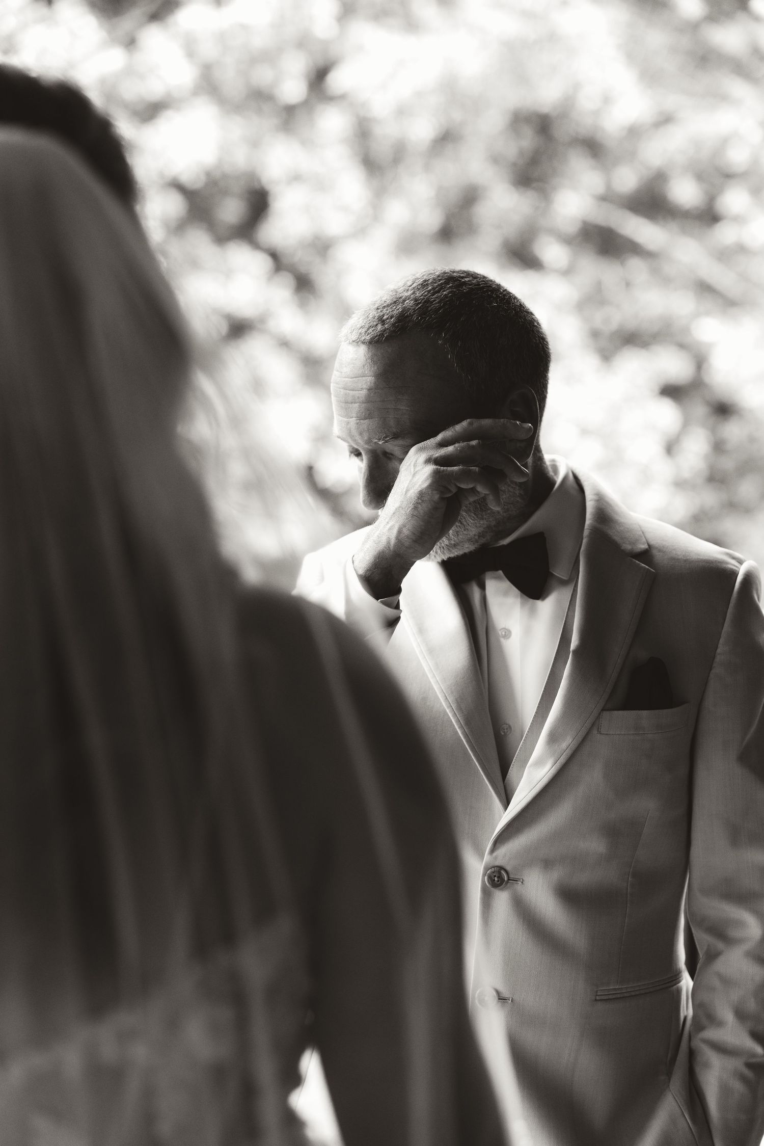 A black and white photographic series showing someone in formal attire bowing their head in a dramatic sequence.