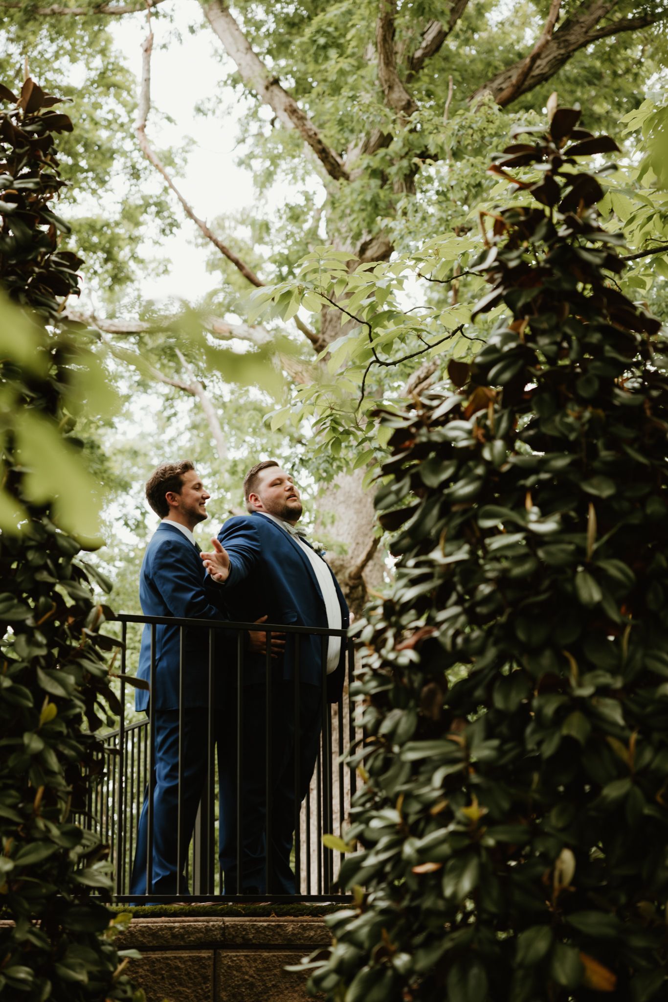 Two people enjoying a peaceful moment on a balcony surrounded by lush greenery.