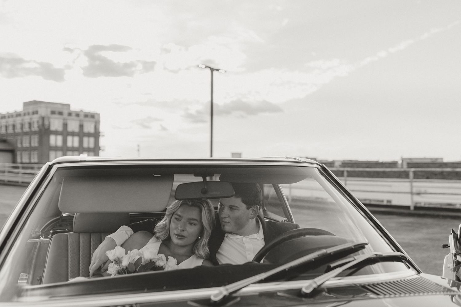 Black and white photo series of a couple sharing joyful moments in a car.