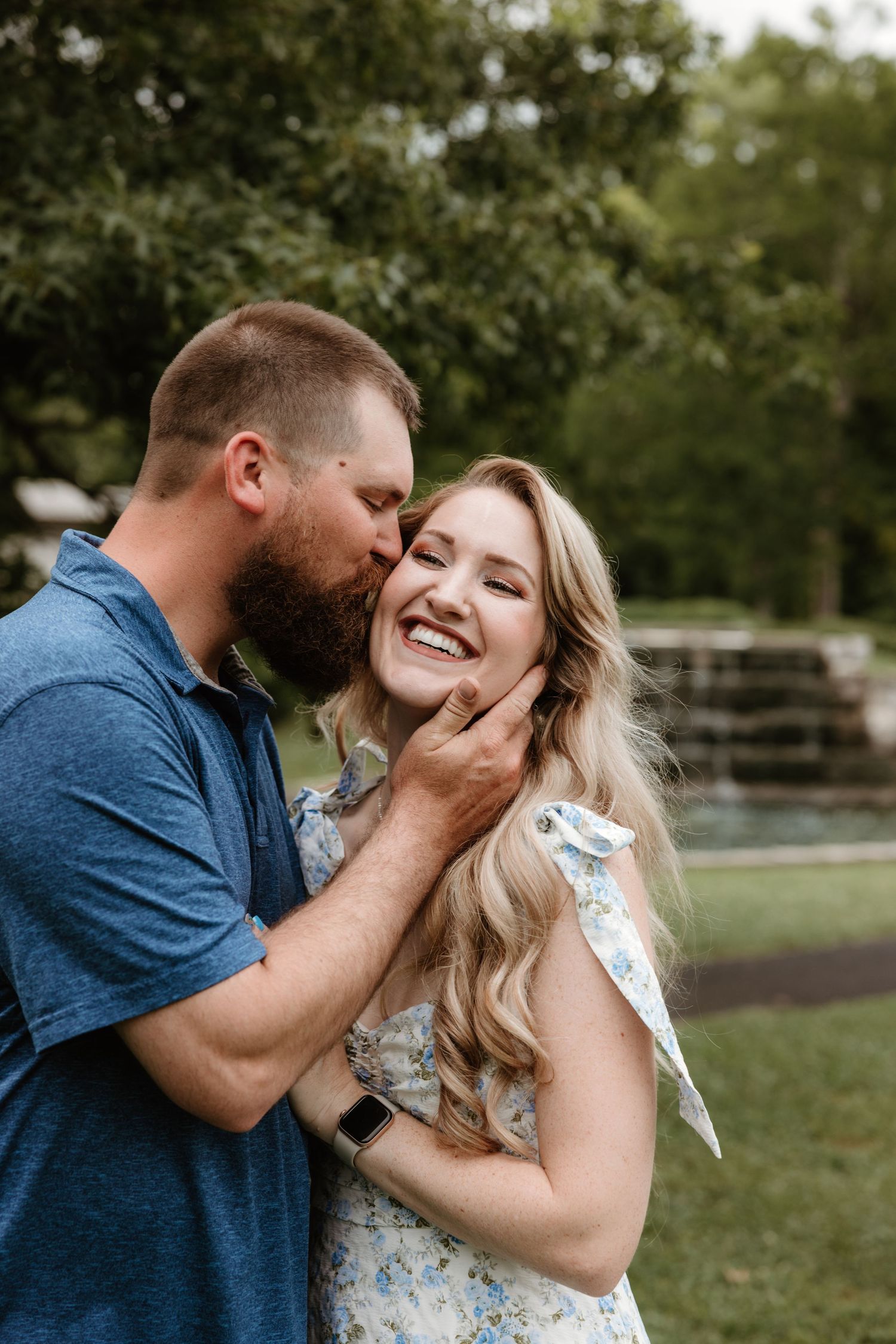 A tender moment shared between a couple in a garden setting.