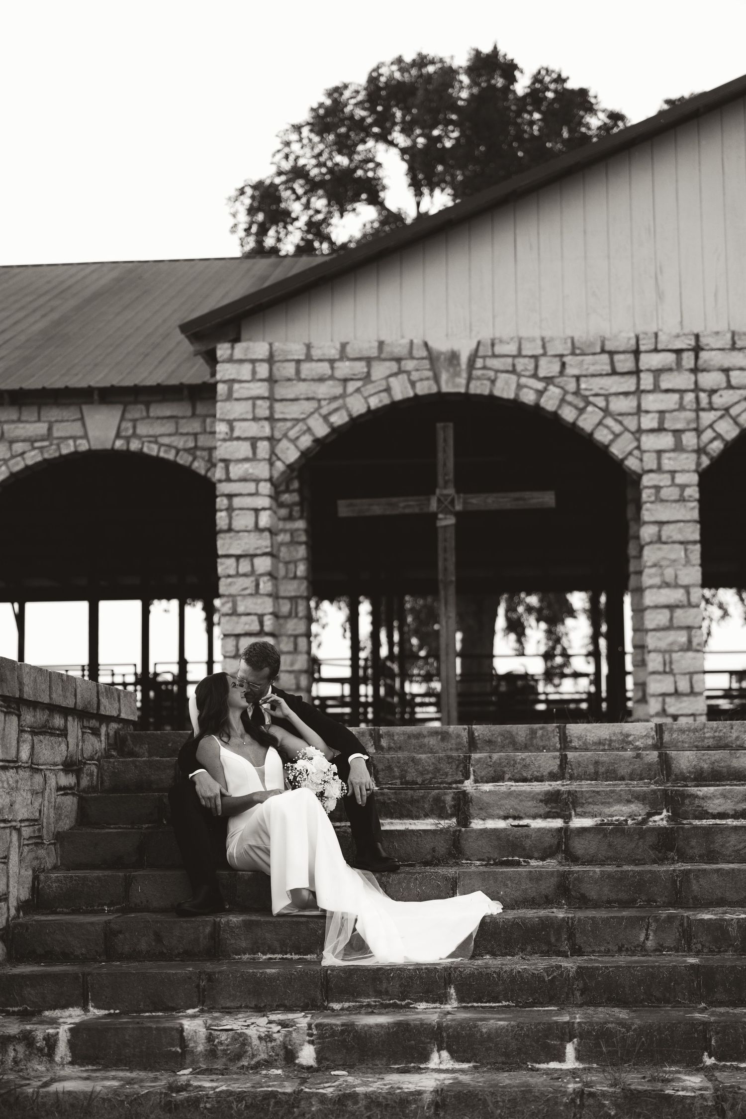 A sequence of six black and white photographs showing a couple posing across stone steps in an outdoor garden setting.
