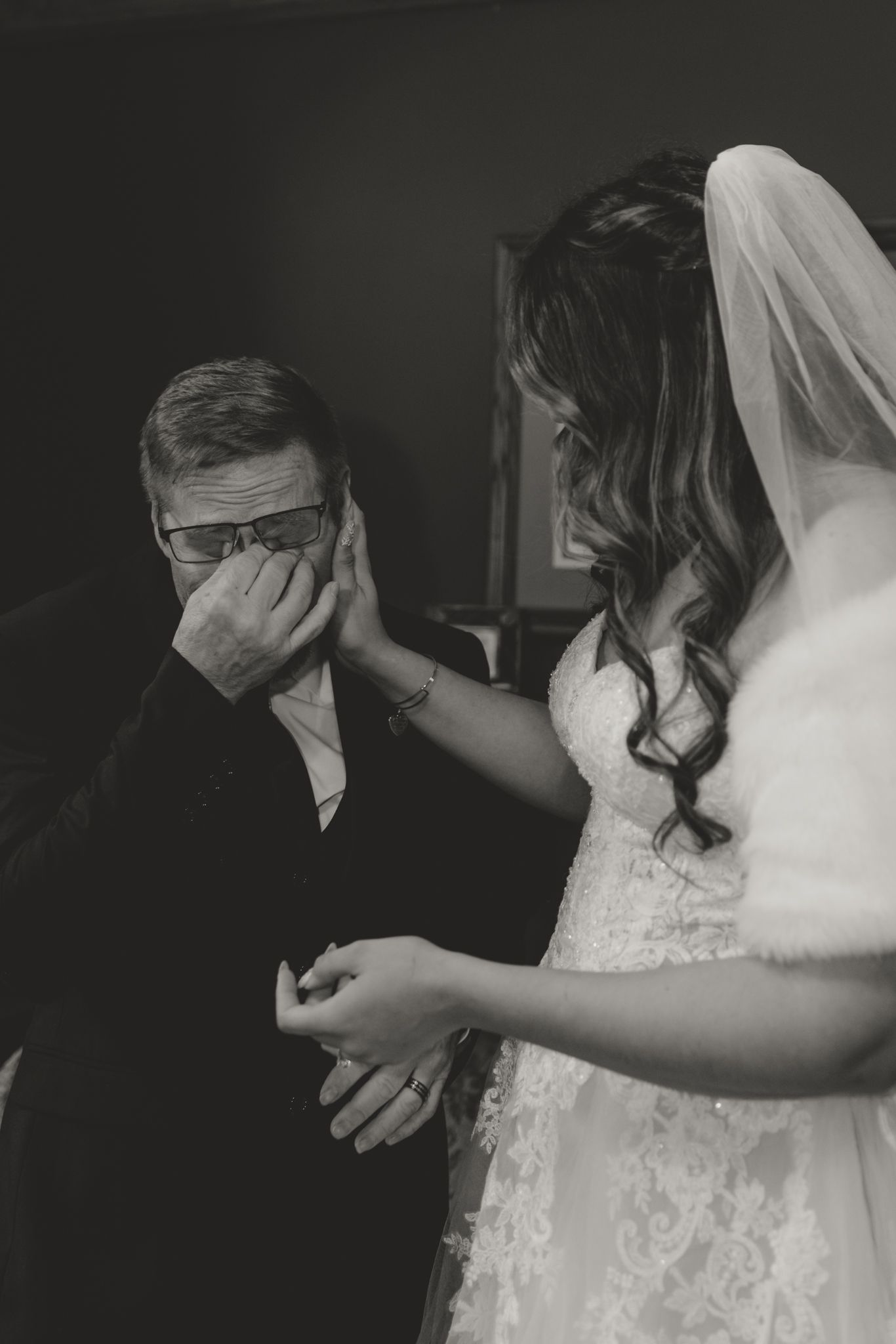 An emotional moment captured in black and white as a bride comforts someone during a wedding day.