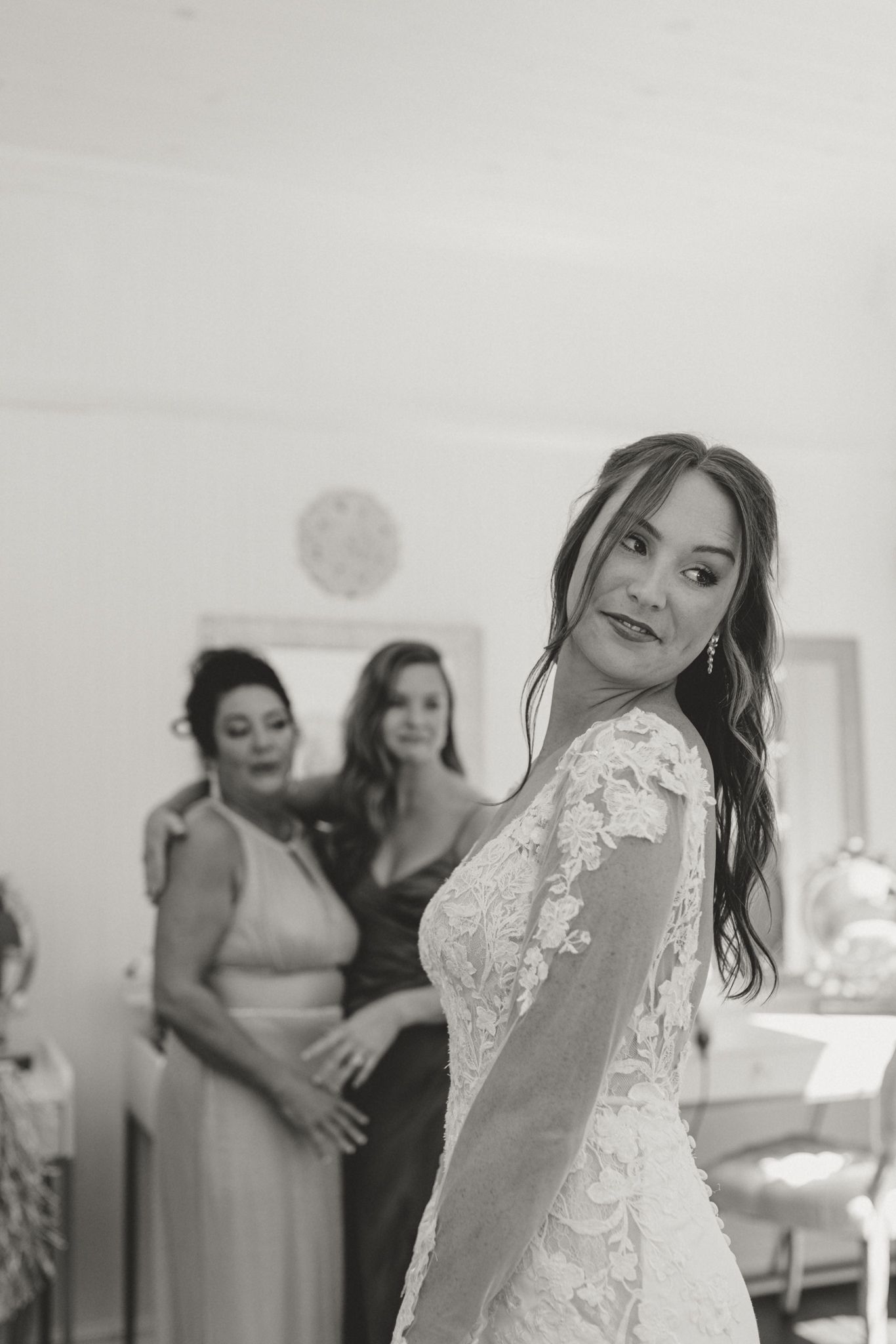 A bride in a lace wedding dress posing during final preparations.