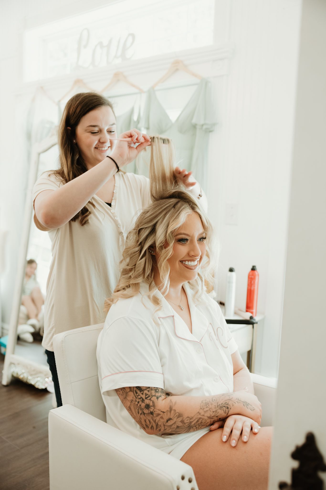 Wedding preparation scene in a bright white room with styling tools and decorative elements.