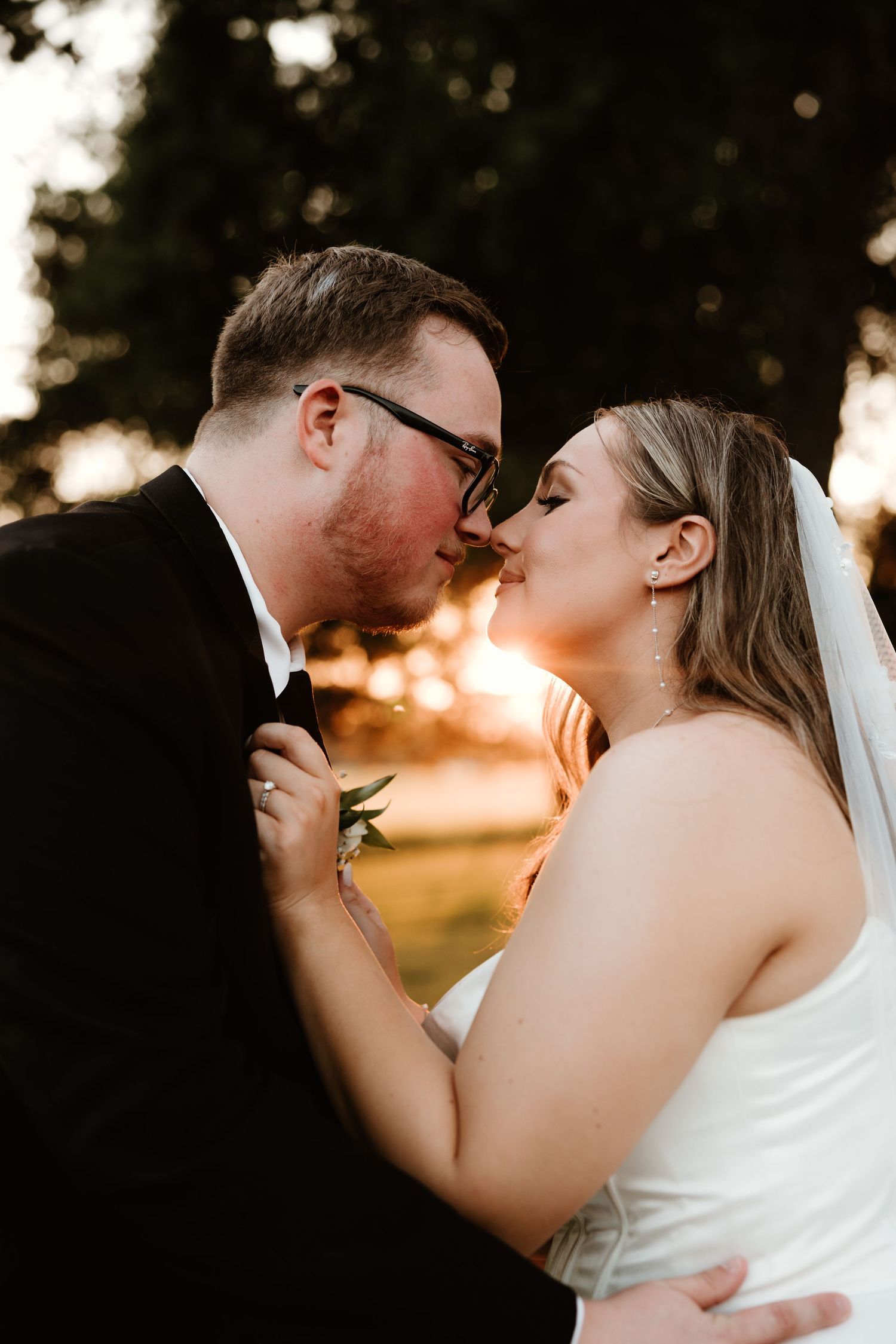 A romantic sunset silhouette shows a couple in a tender embrace during their wedding photoshoot.
