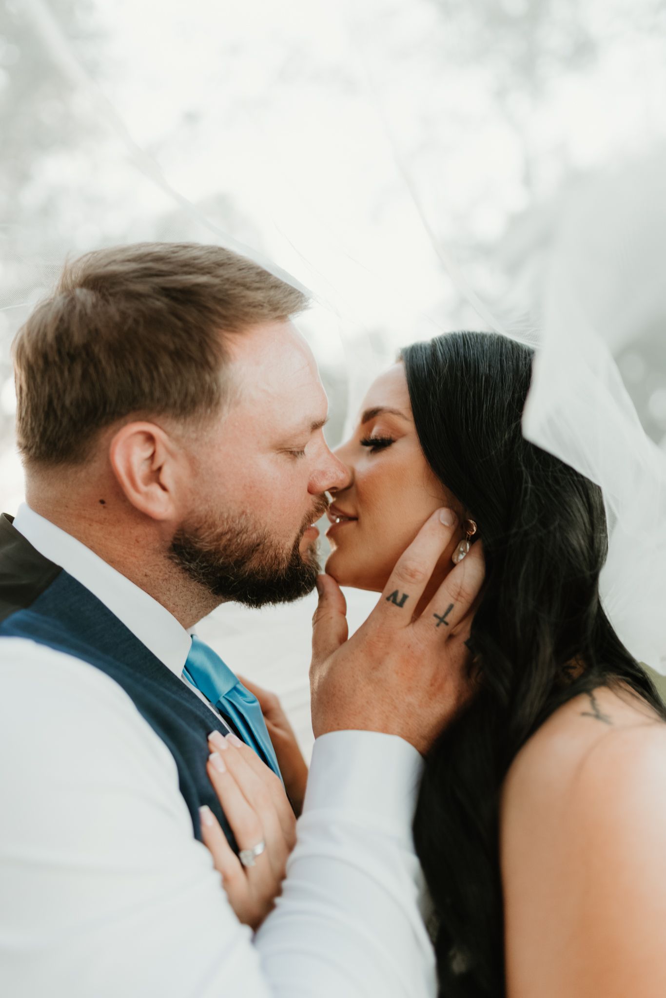 Intimate close-up photos of a tender kiss between newlyweds against a bright background.