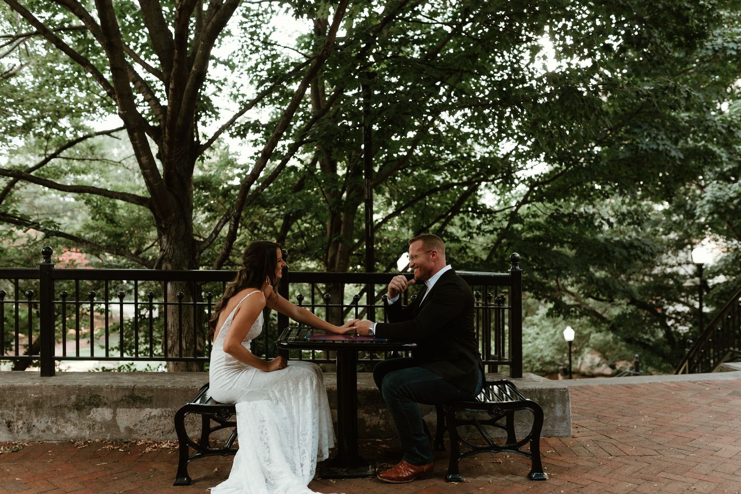 A row of romantic wedding photos set in a lush garden walkway with overhanging trees and natural greenery.