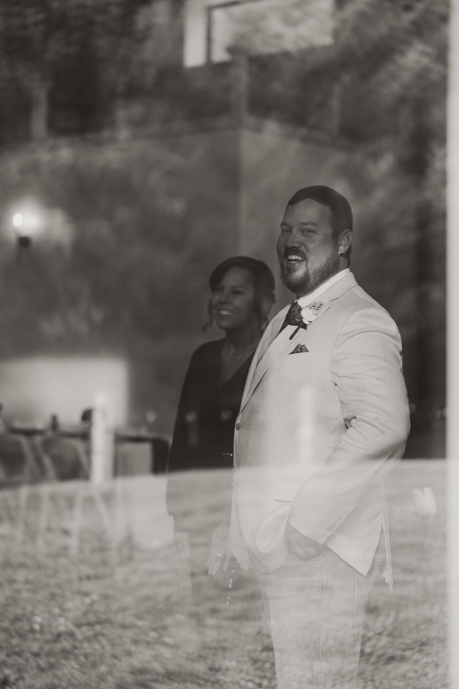 Multiple exposure black and white photograph showing laughing person in white suit and tie progressing across frame.
