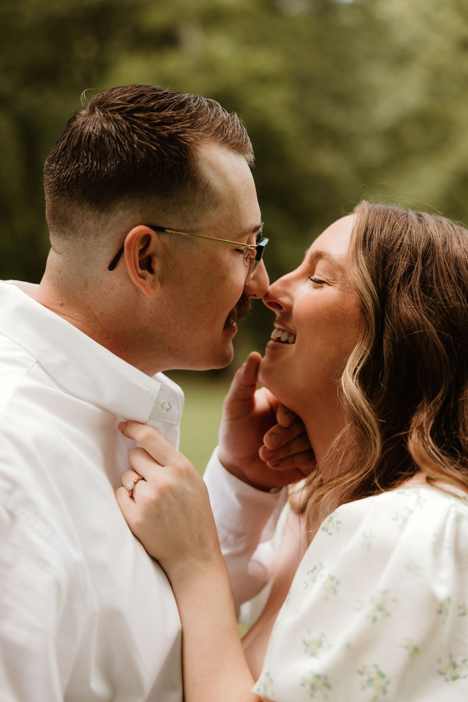 Close up portrait of a romantic couple sharing an intimate moment outdoors in natural lighting.