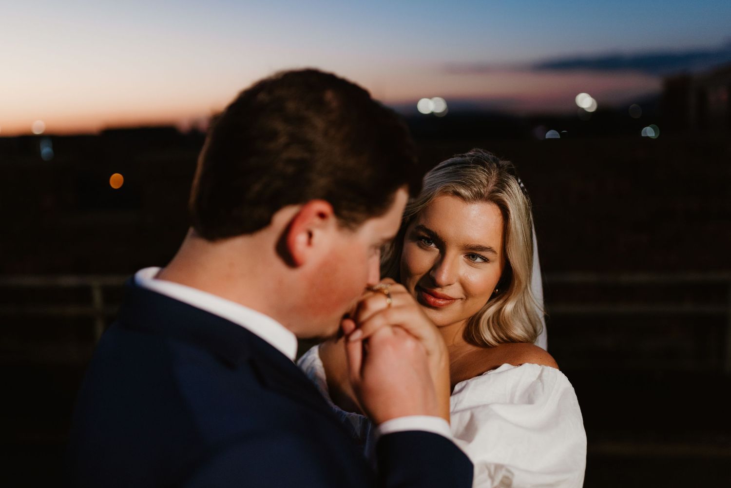 A romantic outdoor wedding photoshoot showcasing tender moments between the couple at twilight.