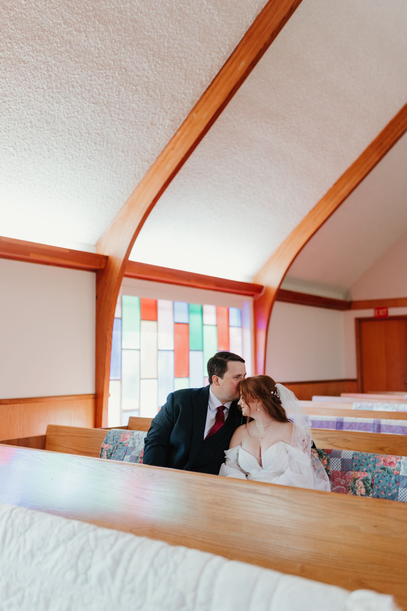 Two attic rooms with slanted ceilings and colorful windows are connected by a playful fisheye lens perspective.