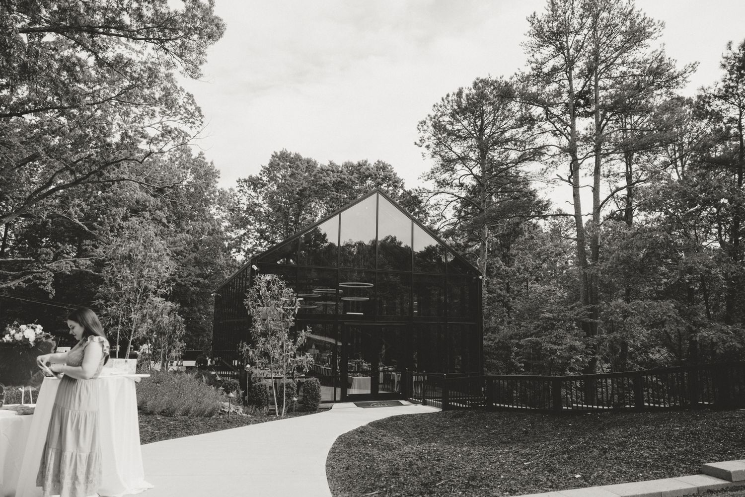 A landscape photo showing exterior grounds of a wedding venue with tall pine trees.