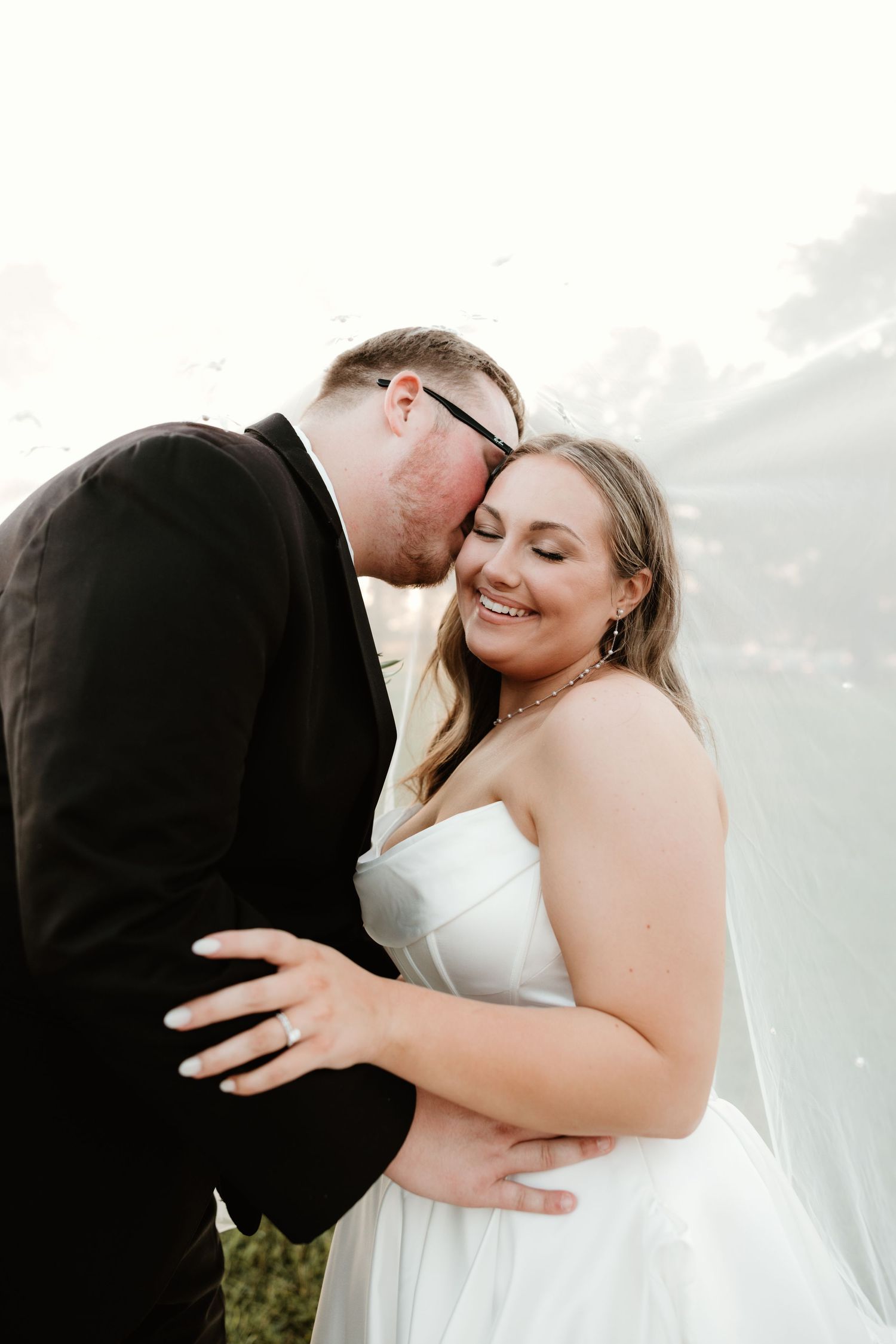 An intimate wedding photography sequence shows a couple embracing under flowing white fabric at different angles.