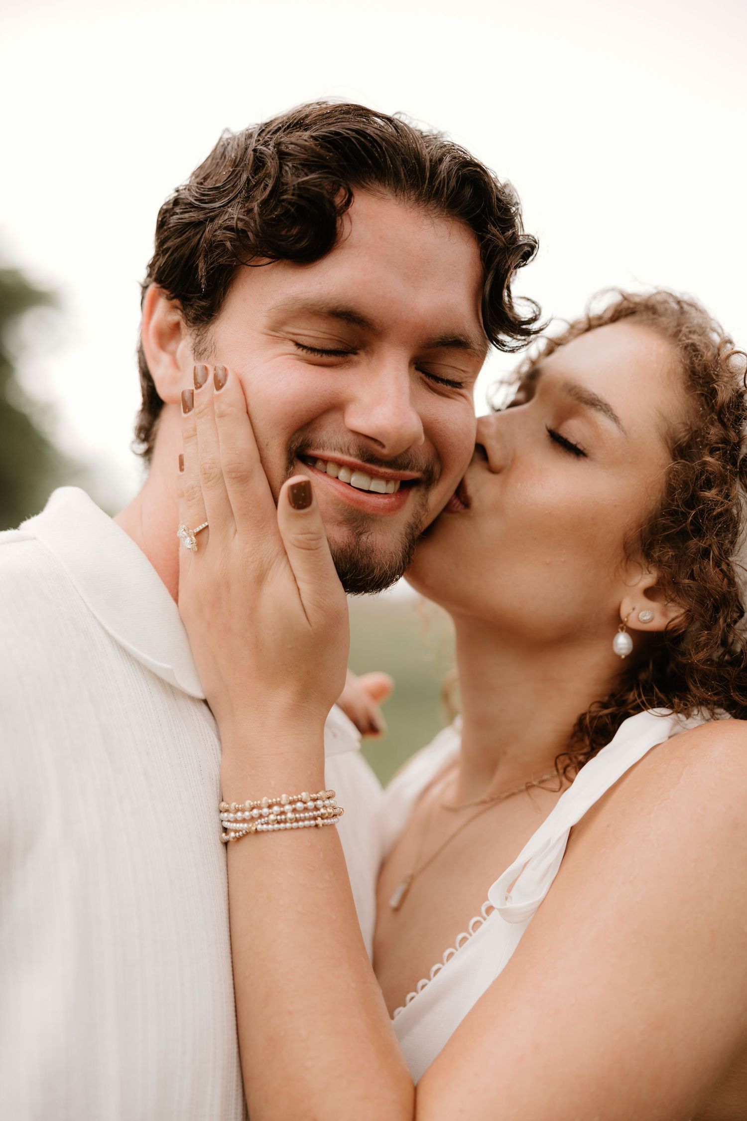 Candid moments captured of a romantic couple sharing tender kisses during an outdoor wedding photoshoot.