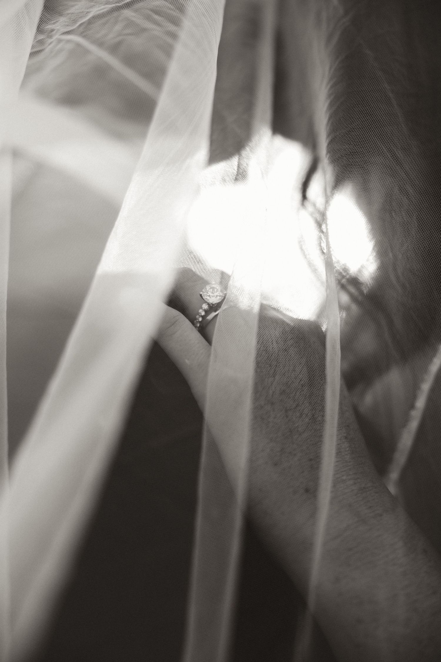 Abstract black and white artistic wedding photograph with dramatic lighting effects.