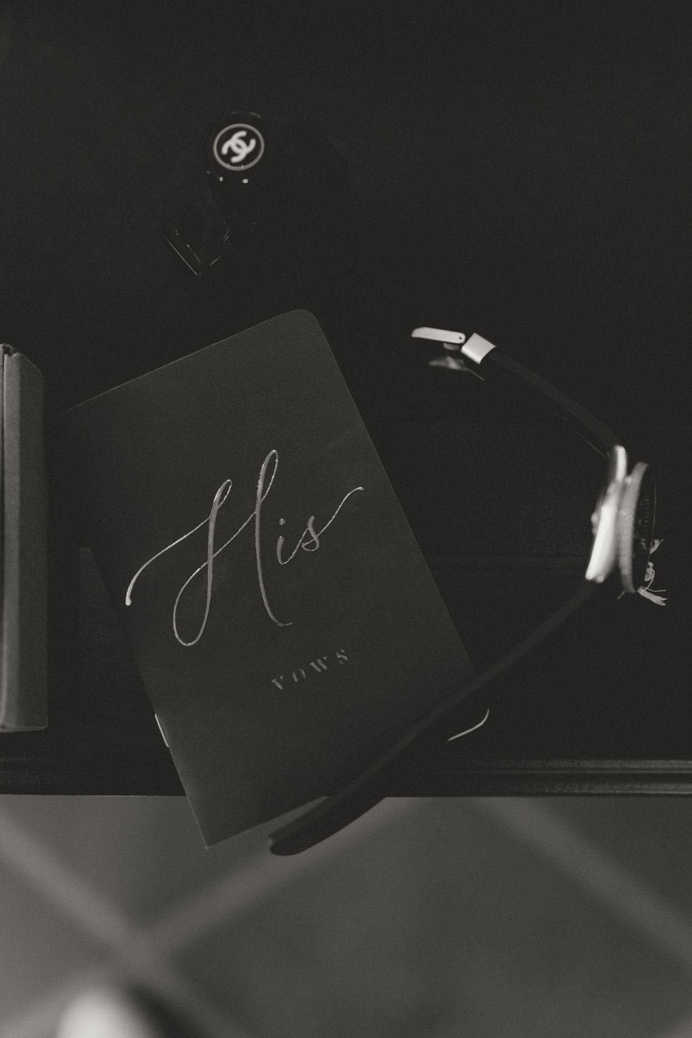 A black and white monochromatic photo shows a book titled 'His' with elegant cursive lettering against a dark background.