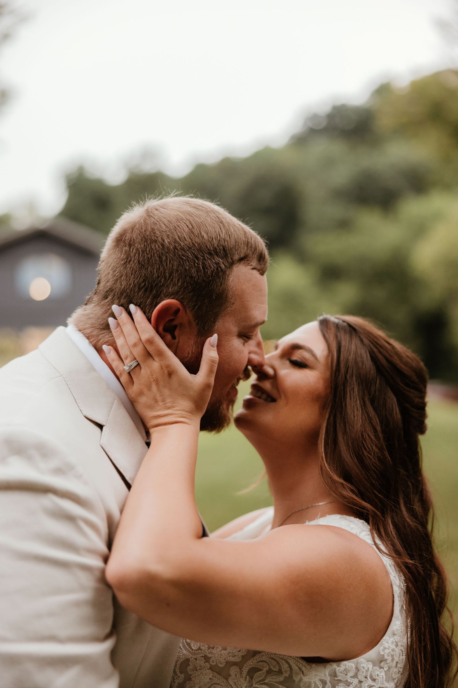 Wedding couple shares romantic kisses in an outdoor garden setting during their special day.