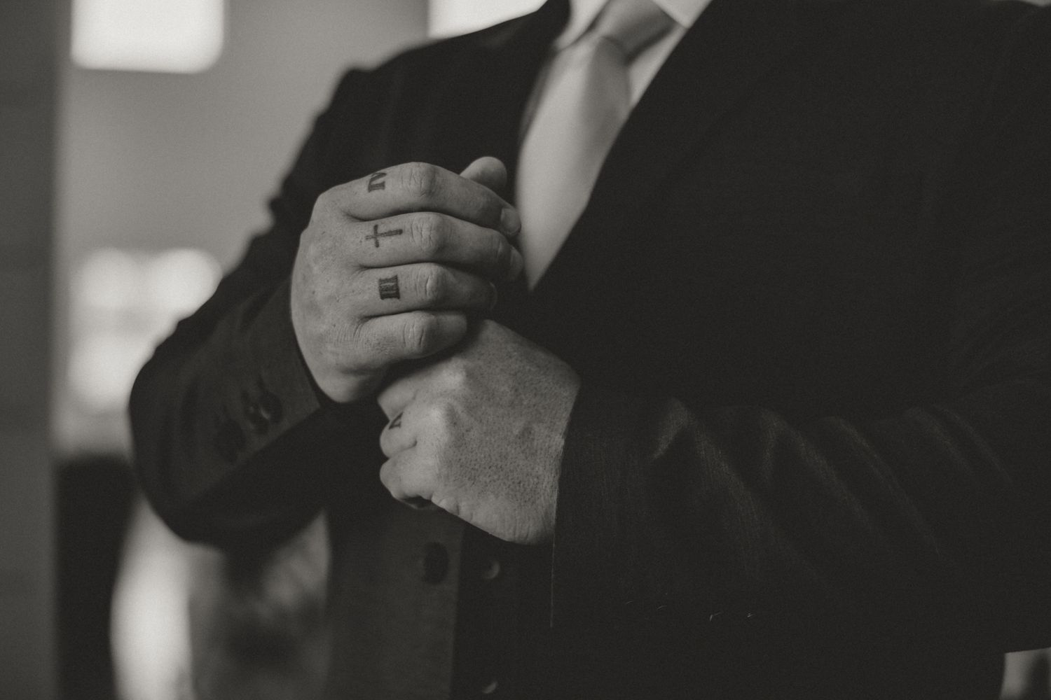 Close-up shots of groom in formal suit and tie getting ready for wedding ceremony.
