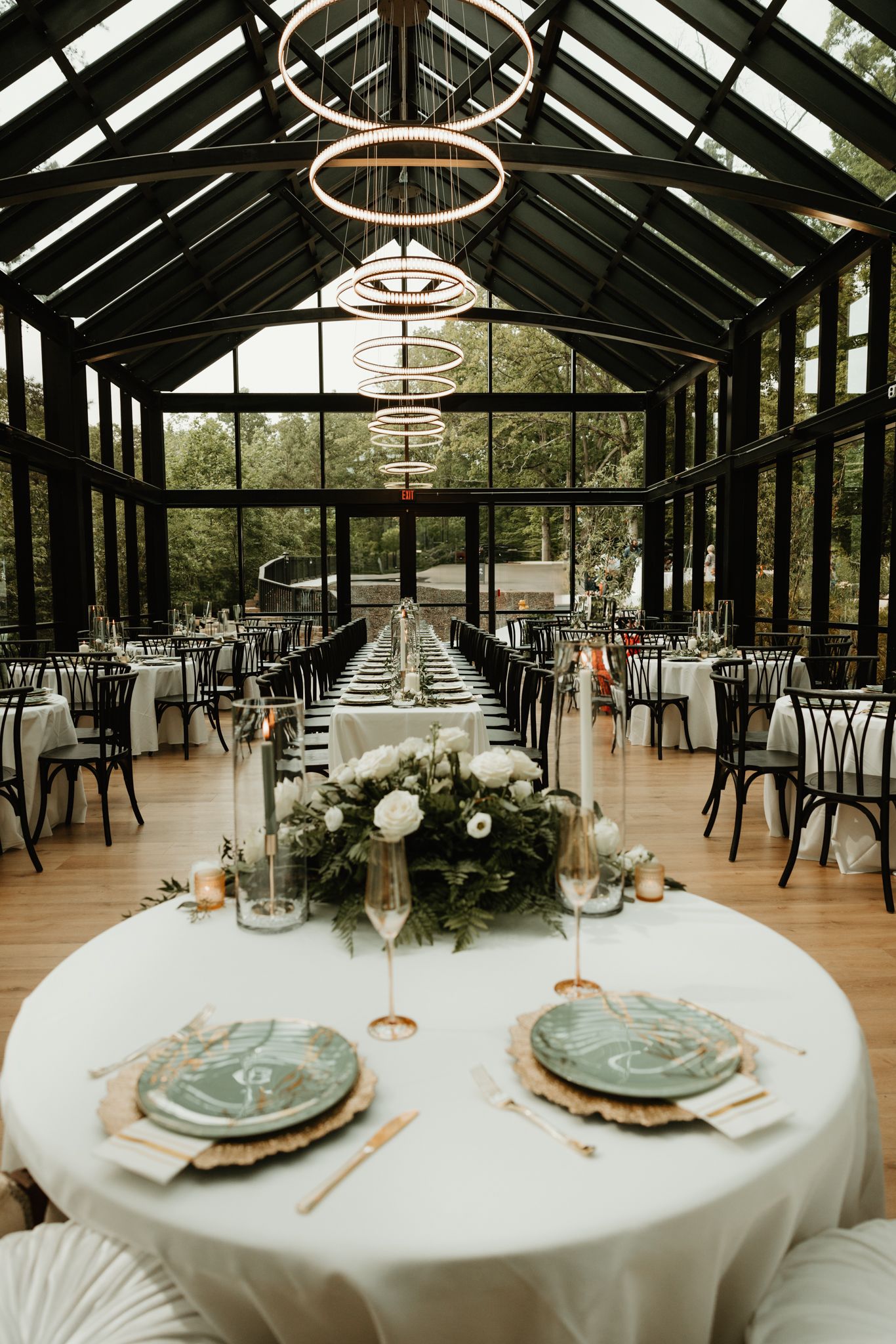 Rustic wooden reception venue interior with elegant table settings and chandelier lighting.