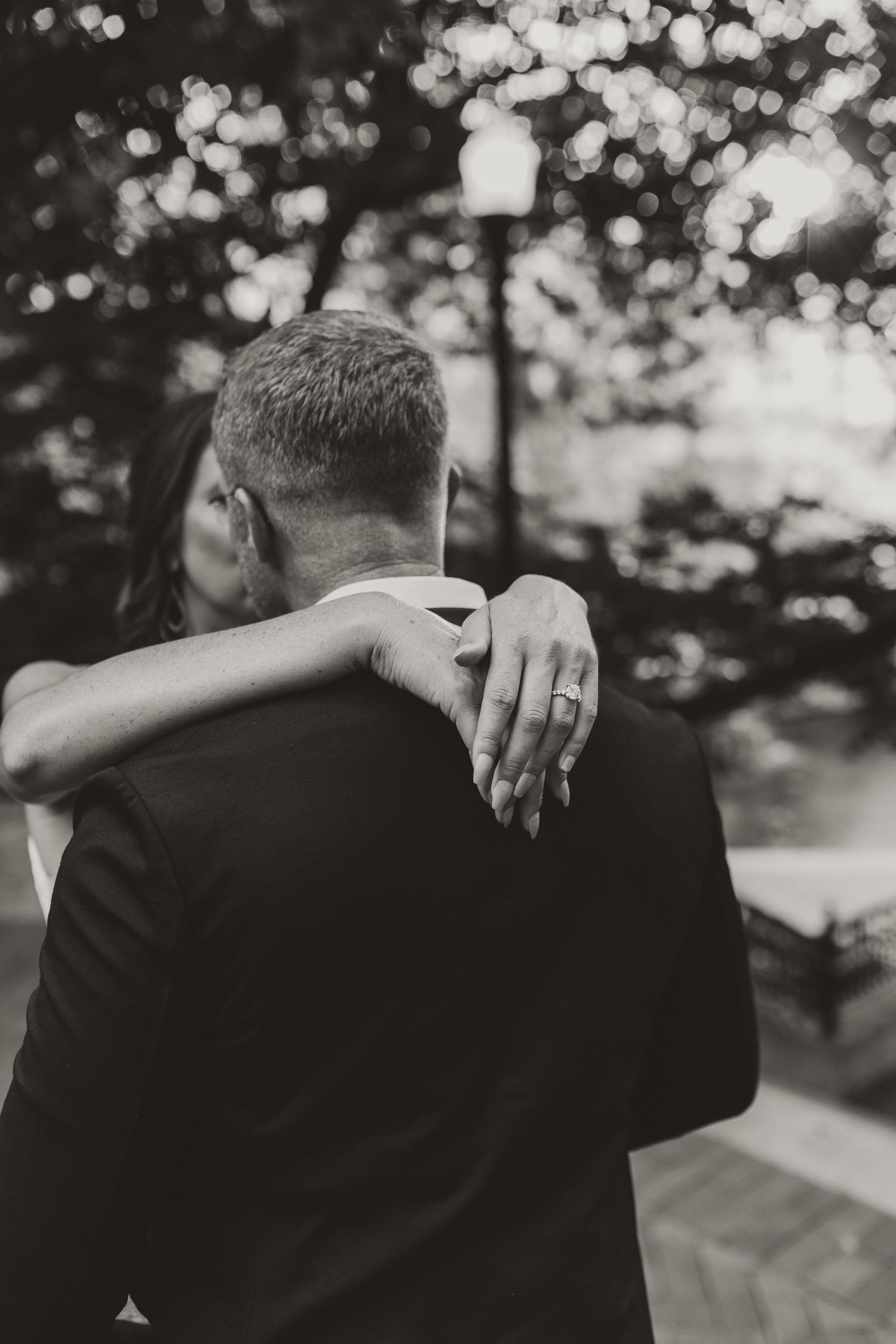 A series of artistic black and white photos showing close-up views of figures in formal wedding attire embracing.