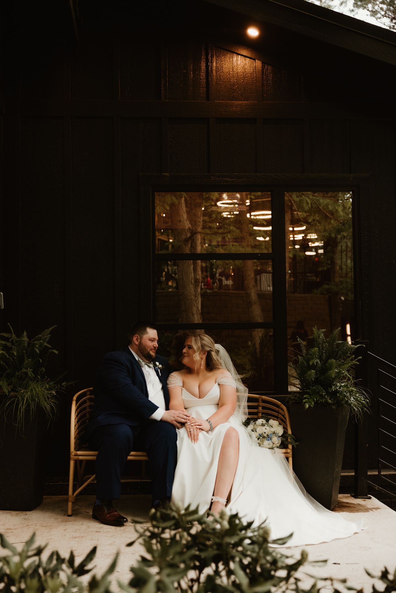 An intimate moment at a wedding reception with vintage-style lighting and decor against a dark backdrop.