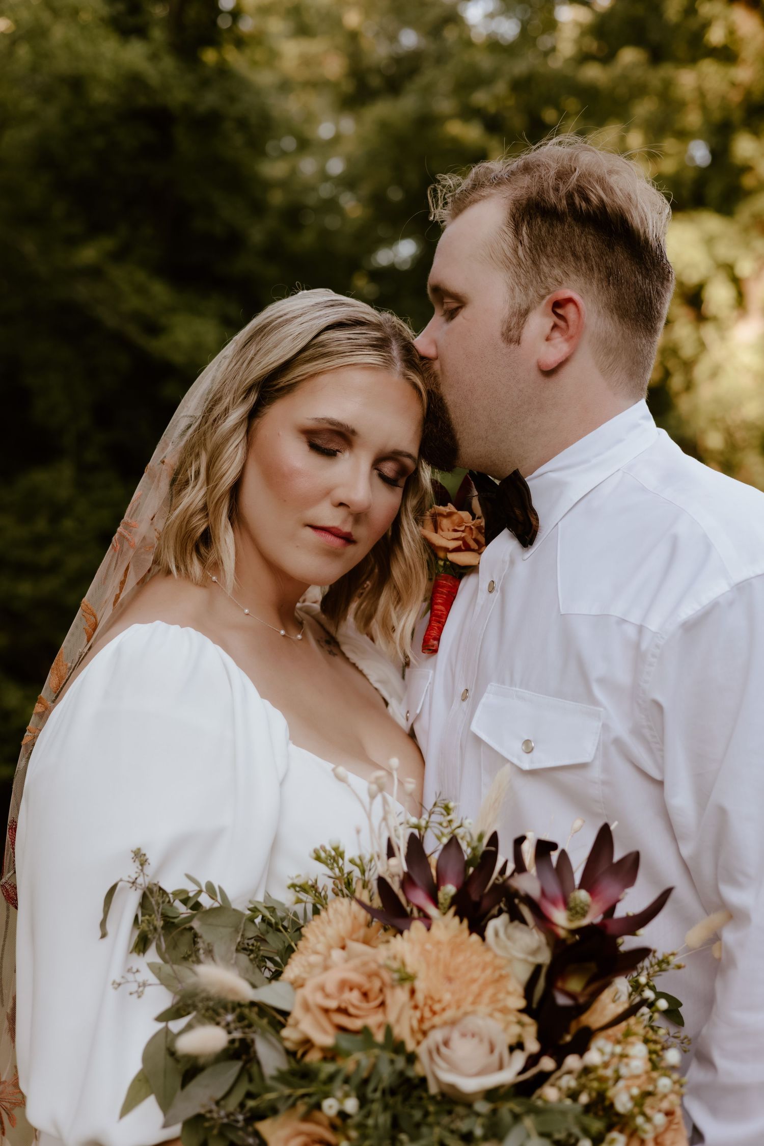 Romantic wedding portraits with soft autumn lighting and delicate floral bouquet.